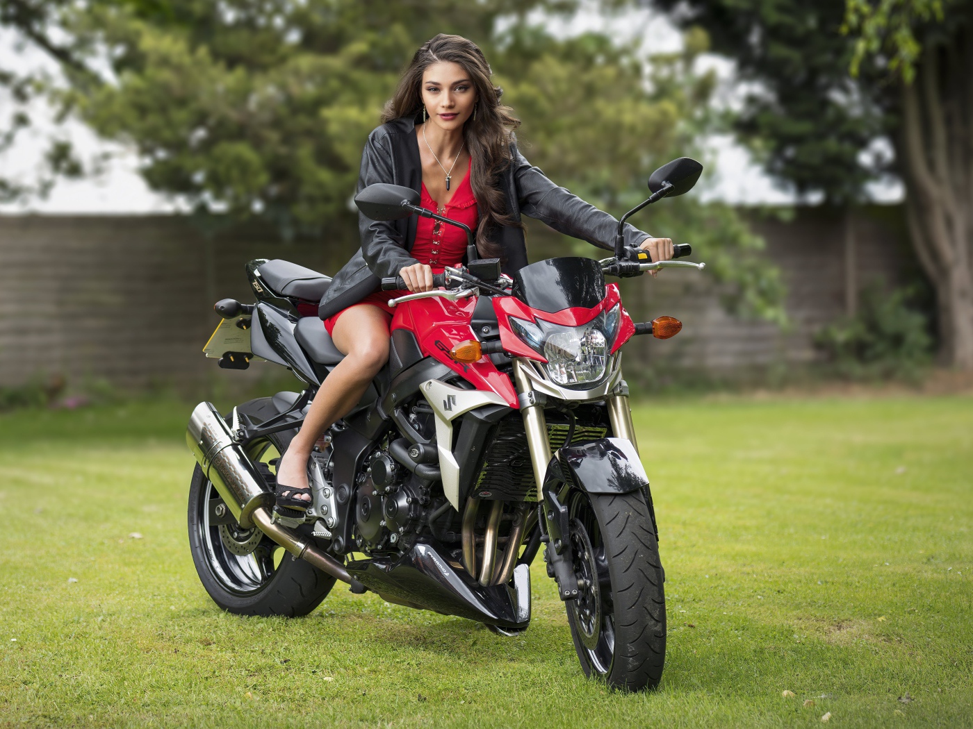 Красивая девушка на мотоцикле в парке 