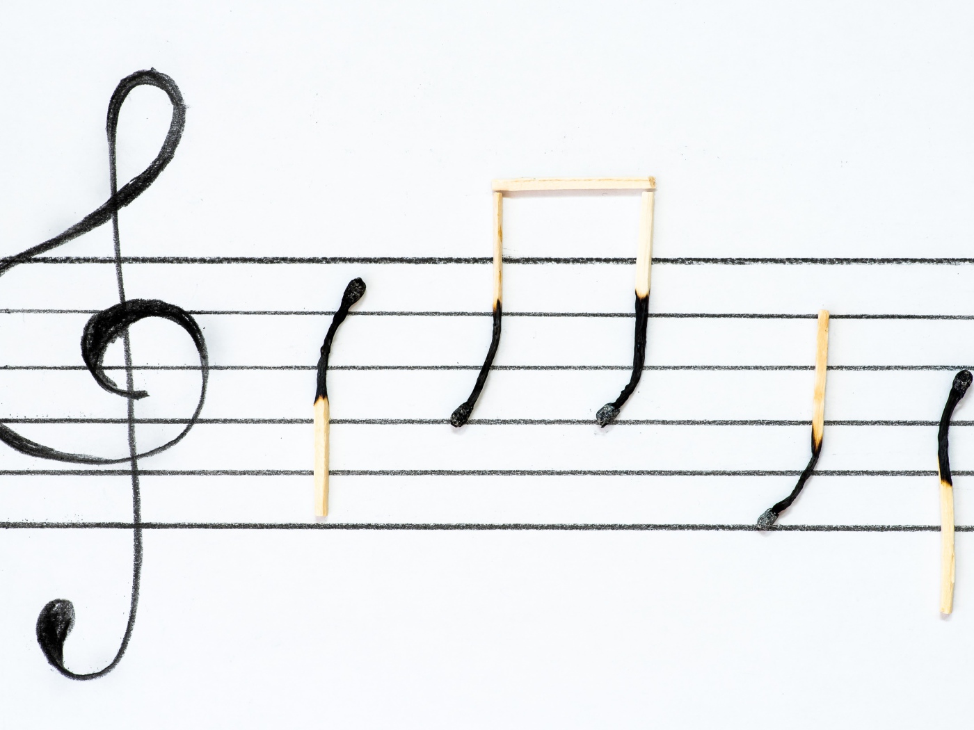 Ноты на белом фоне из сожженных спичек