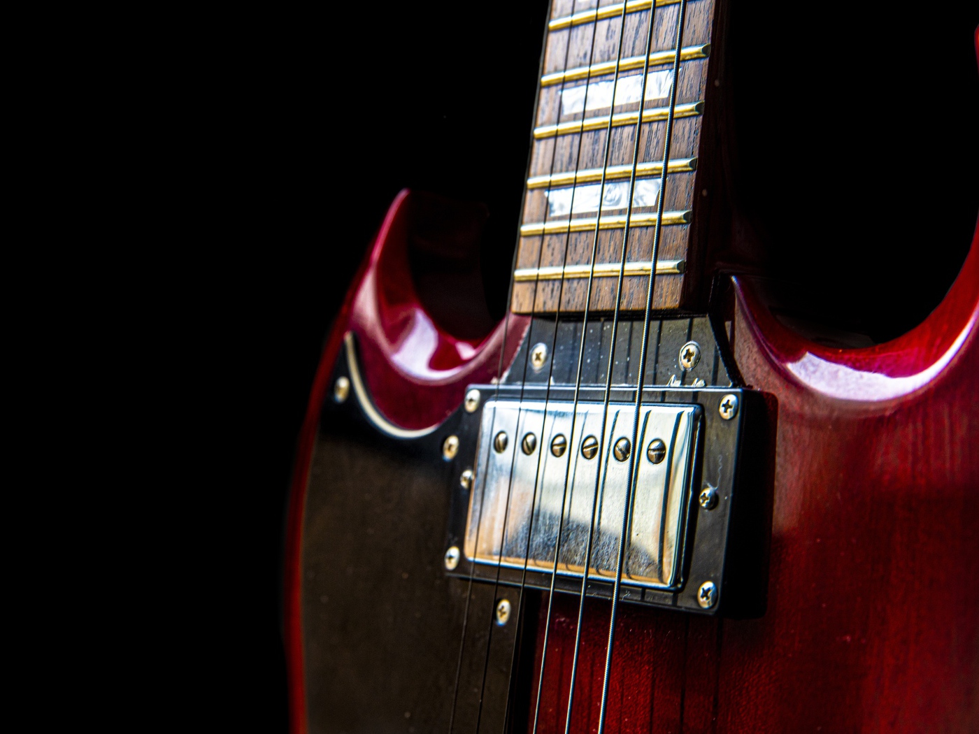 Красная гитара со струнами на черном фоне 