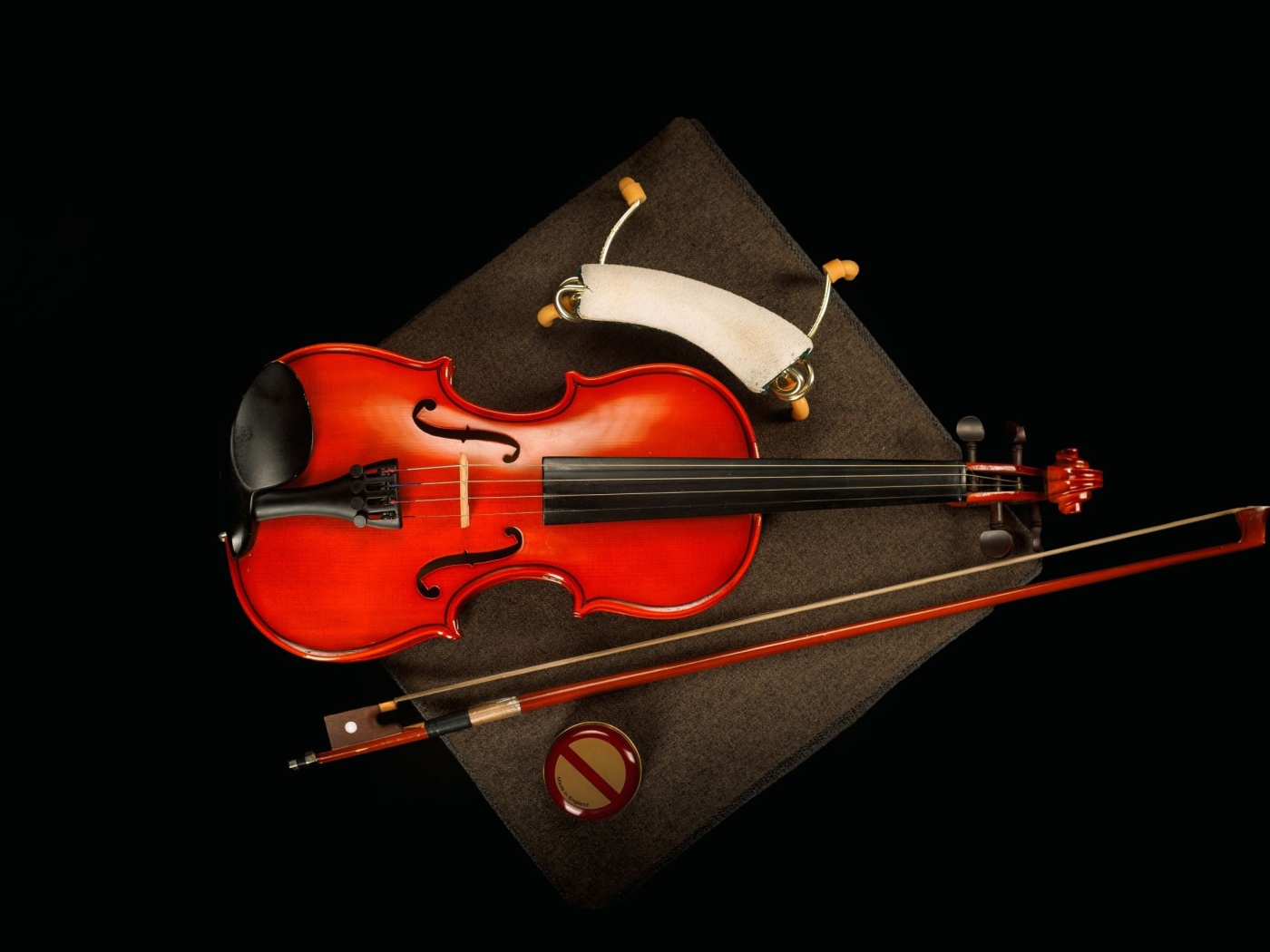 Красная скрипка со смычком на черном фоне
