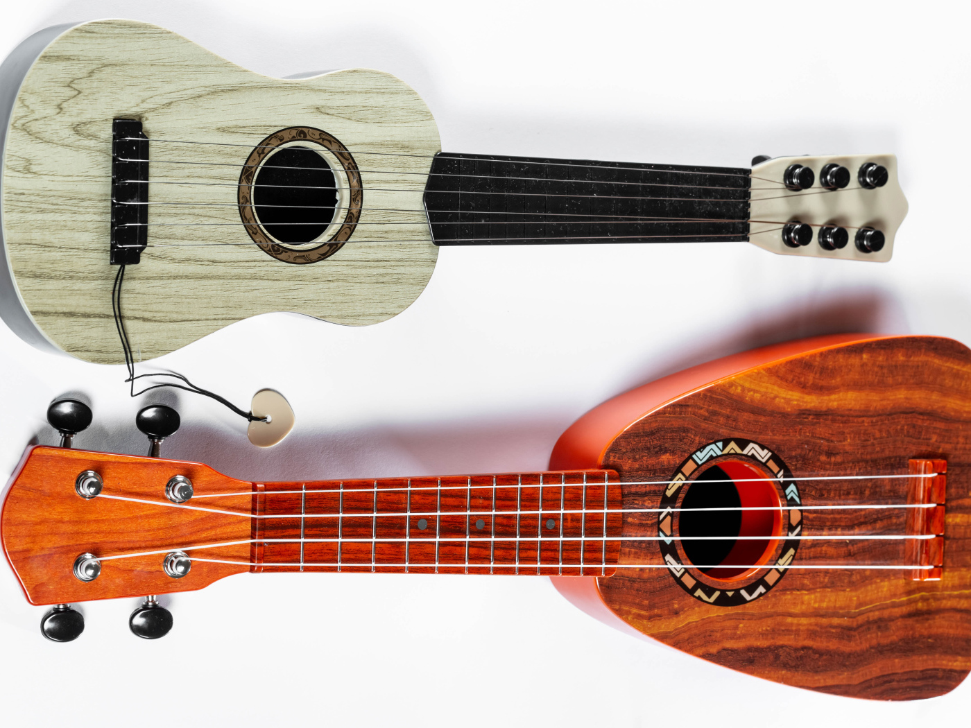 Две маленькие гитары укулеле на белом фоне