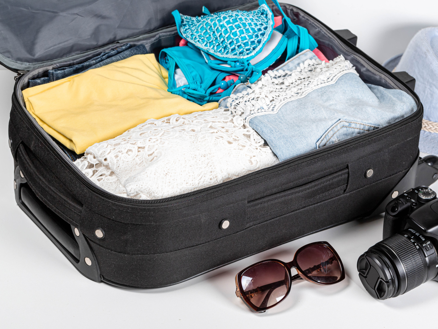 Чемодан с вещами для отпуска с фотоаппаратом и очками 