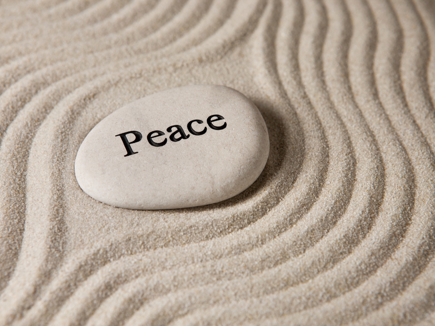 Белый камень с надписью на песке с волнами