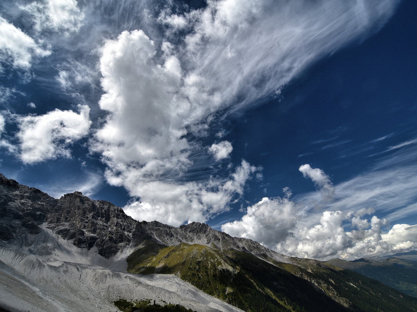 Белые густые облака в голубом небе над горами 