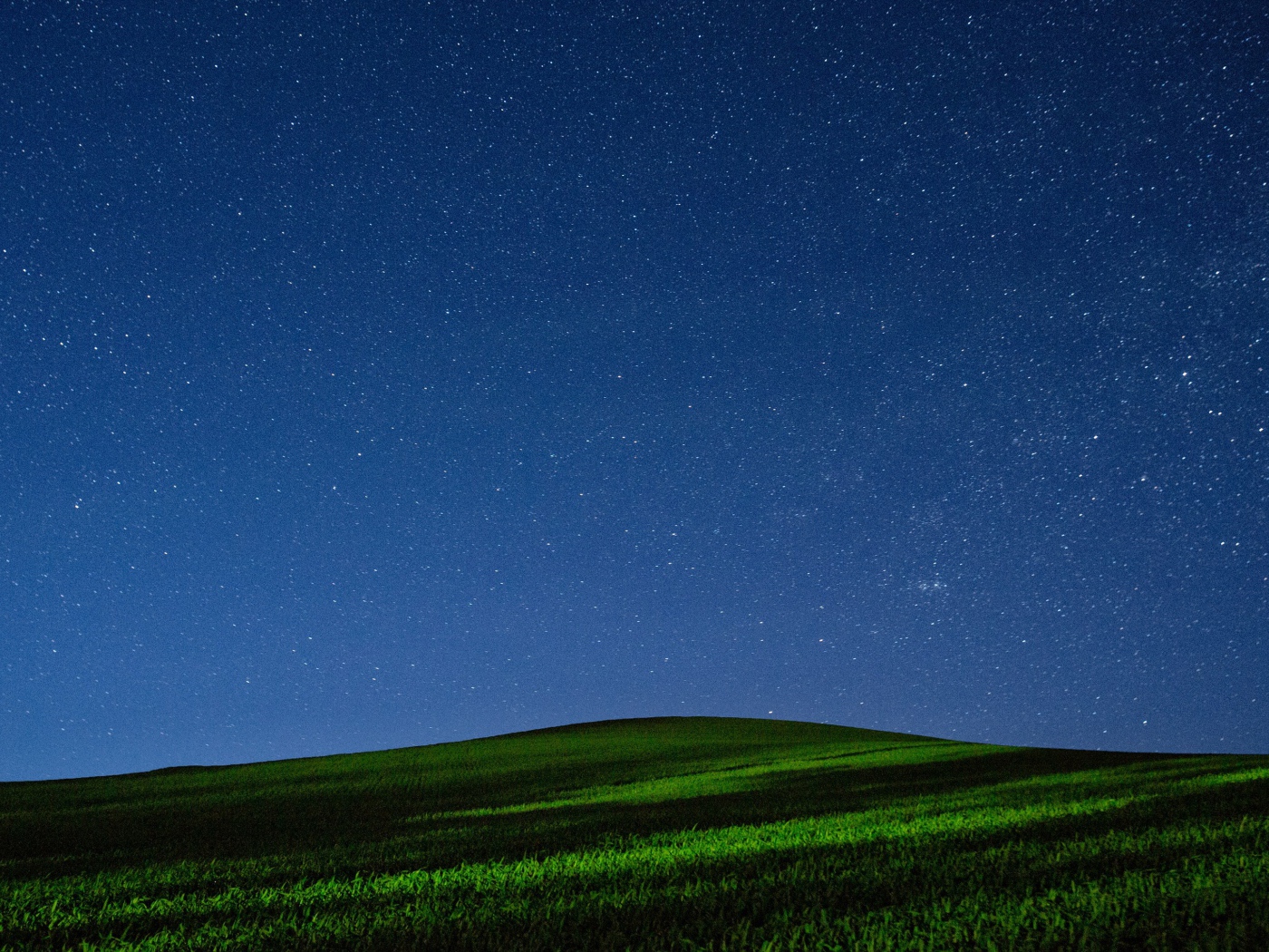 Красивое звездное ночное небо над зеленым полем