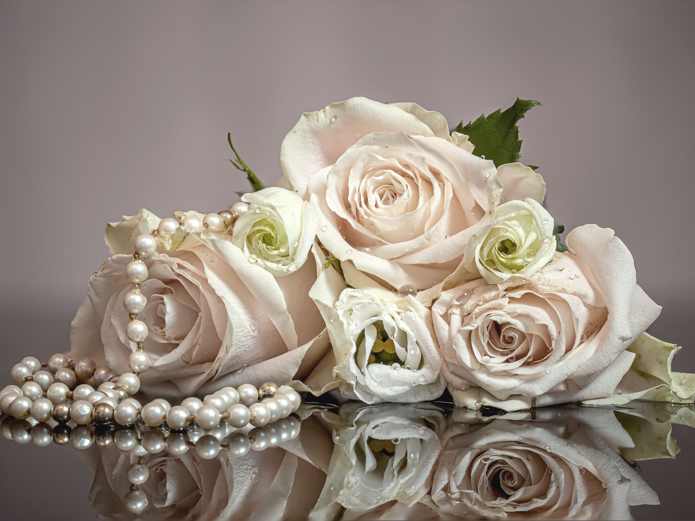 Букет белых роз с бусами на сером фоне
