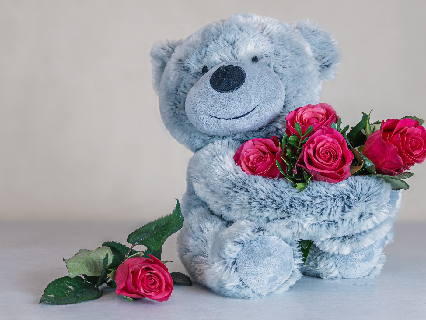 Серый медвежонок с букетом роз