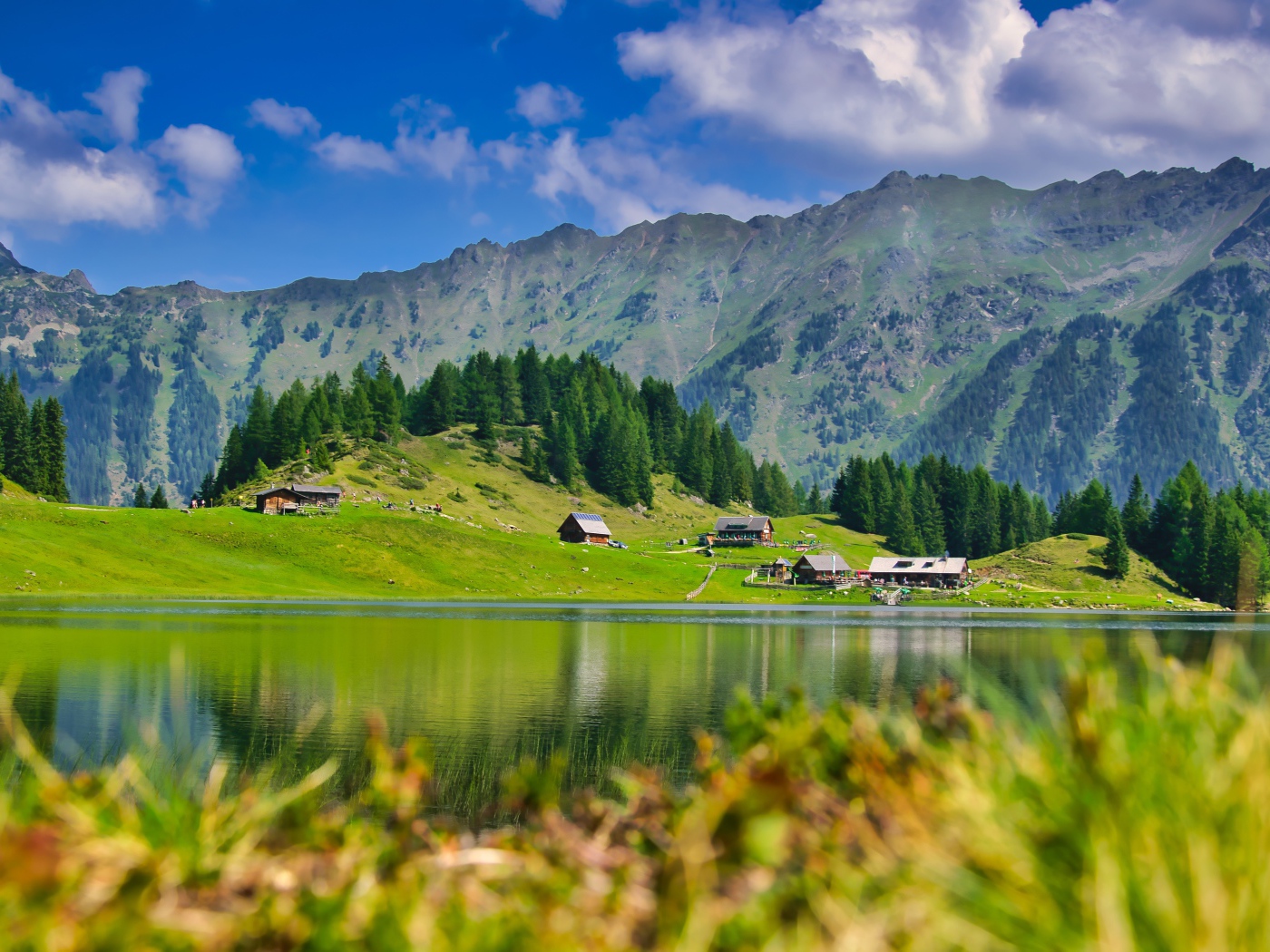 Beautiful landscape of mountains and lake and green meadows