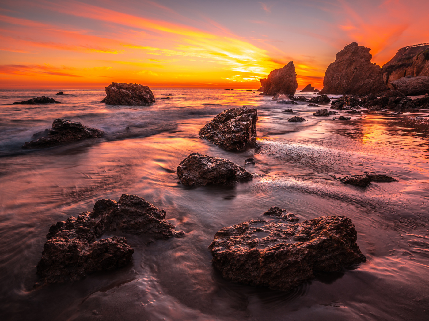 Красивый закат солнца на берегу моря с камнями 