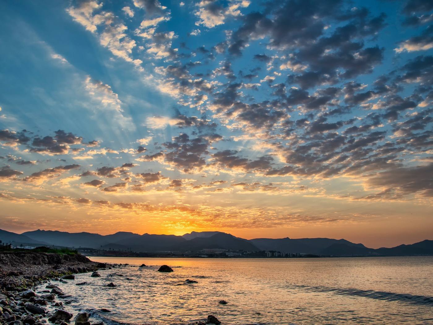 Рассвет солнца за горой у озера 