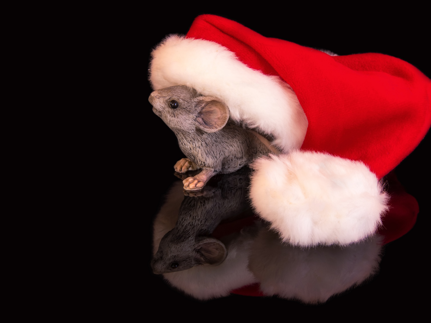 Статуэтка мышка с красным колпаком на черном фоне 