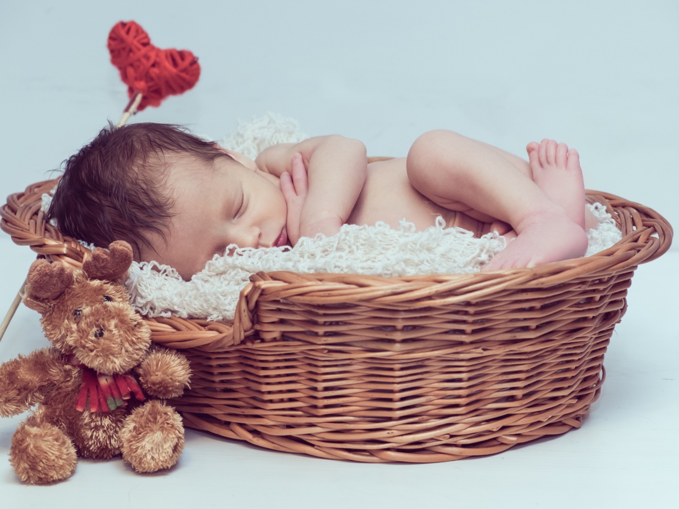 Красивый маленький грудной ребенок спит в корзине с игрушкой 