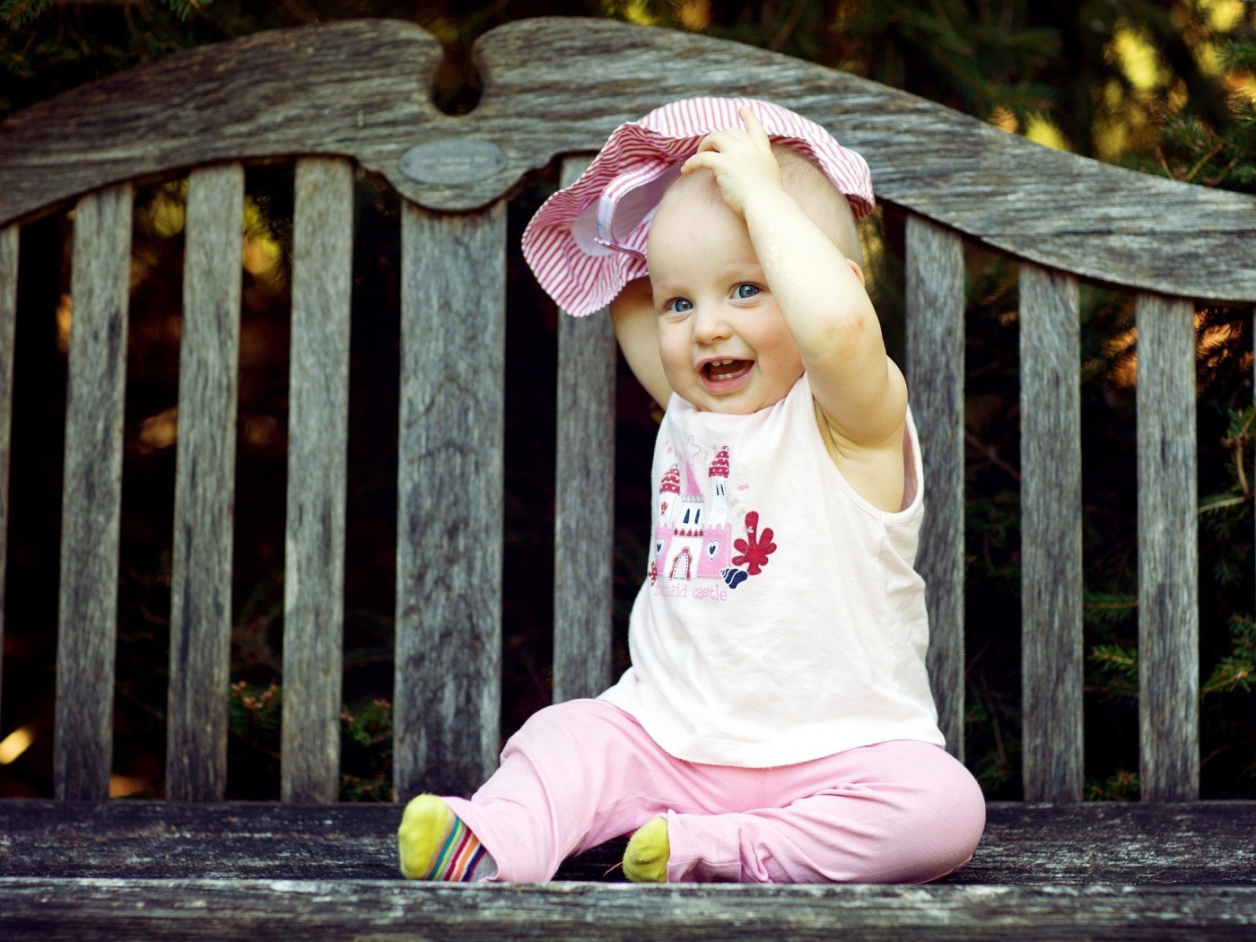 Смешной маленький ребенок сидит на лавке