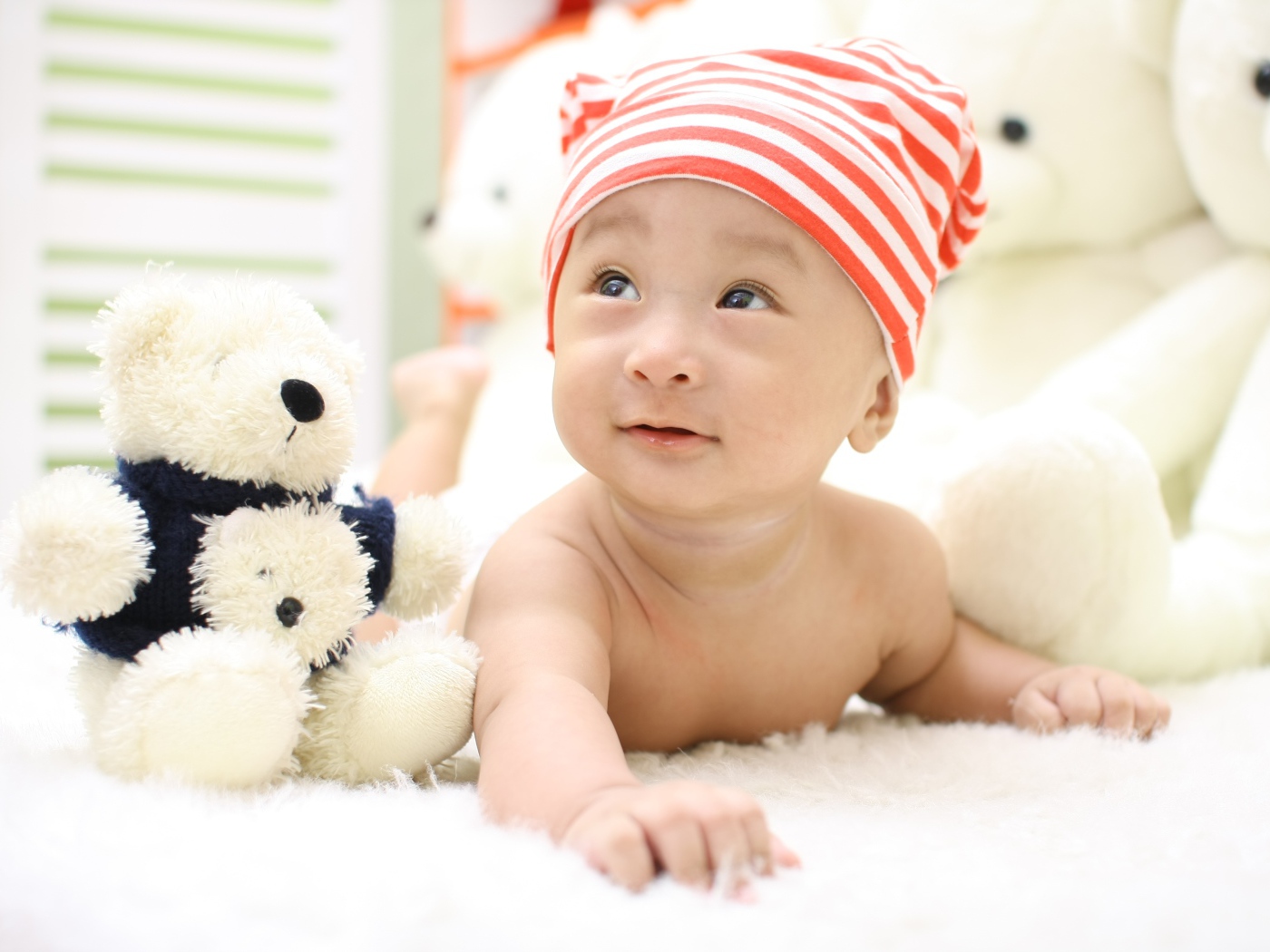 Маленький мальчик азиат на кровати с игрушкой