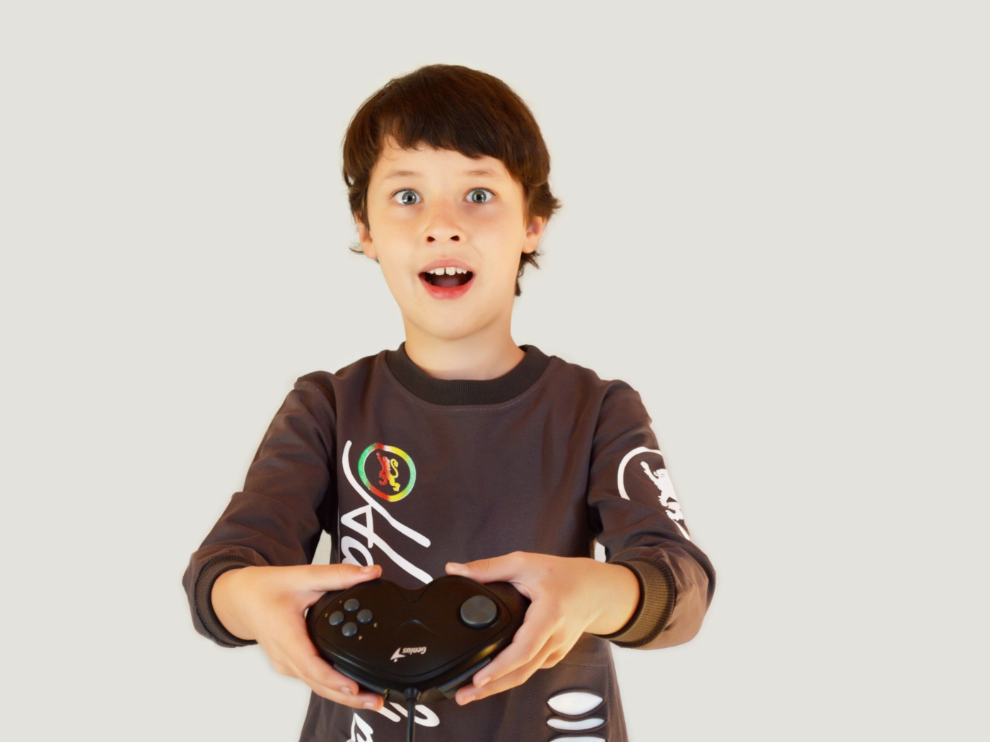 Маленький мальчик с приставкой на сером фоне 