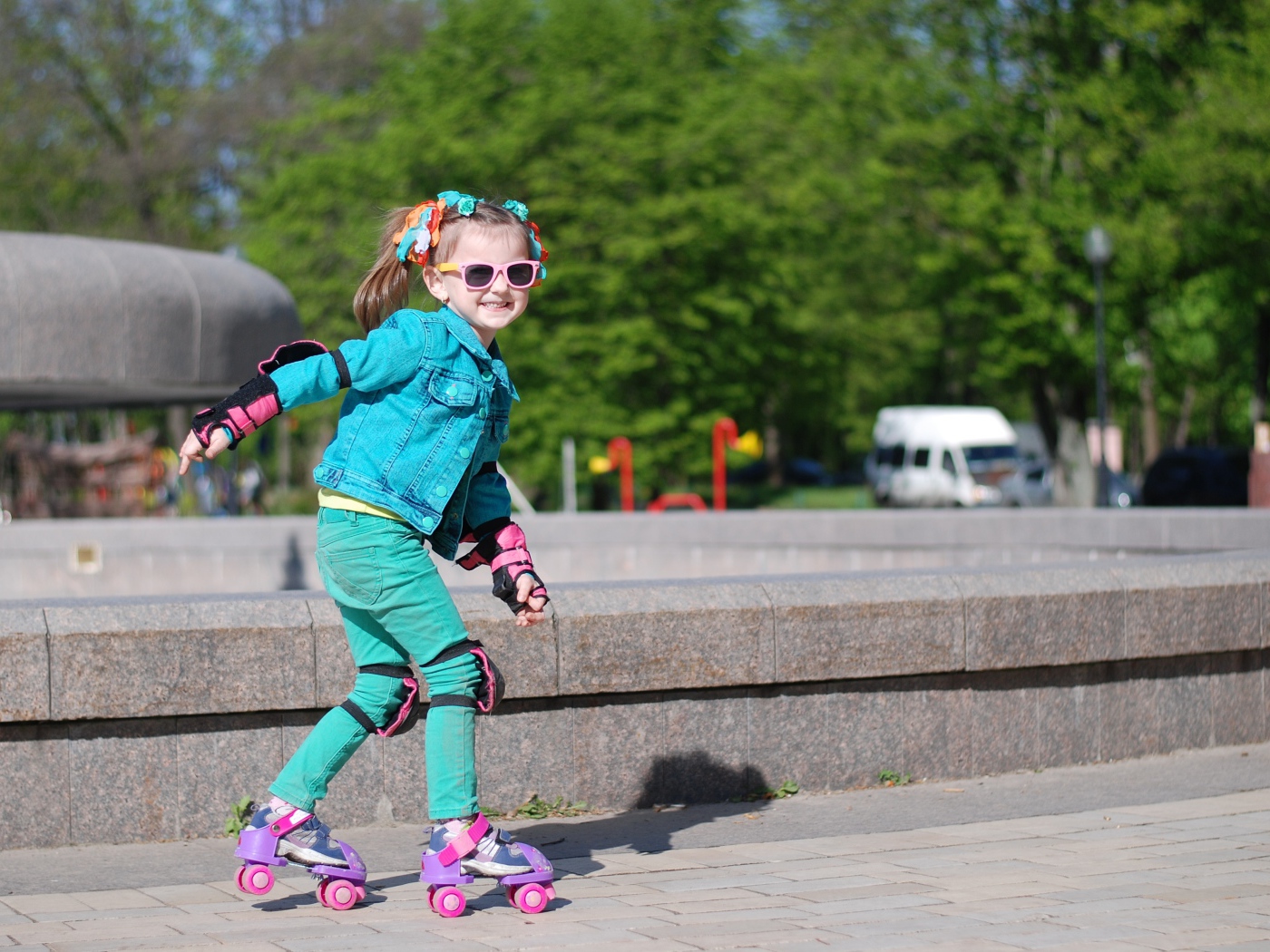 Little cheerful girl rollerblading