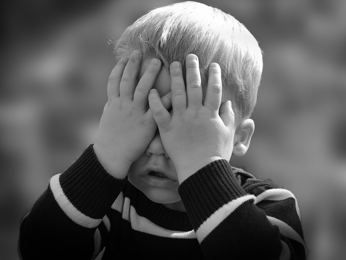 Маленький ребенок закрыл глаза руками