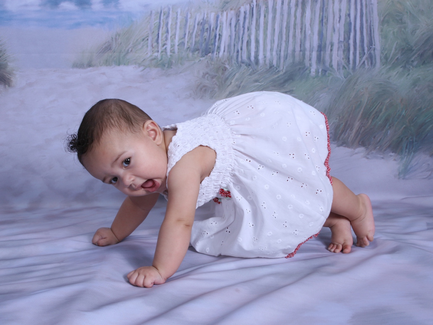 Маленькая девочка в белом платье на кровати 