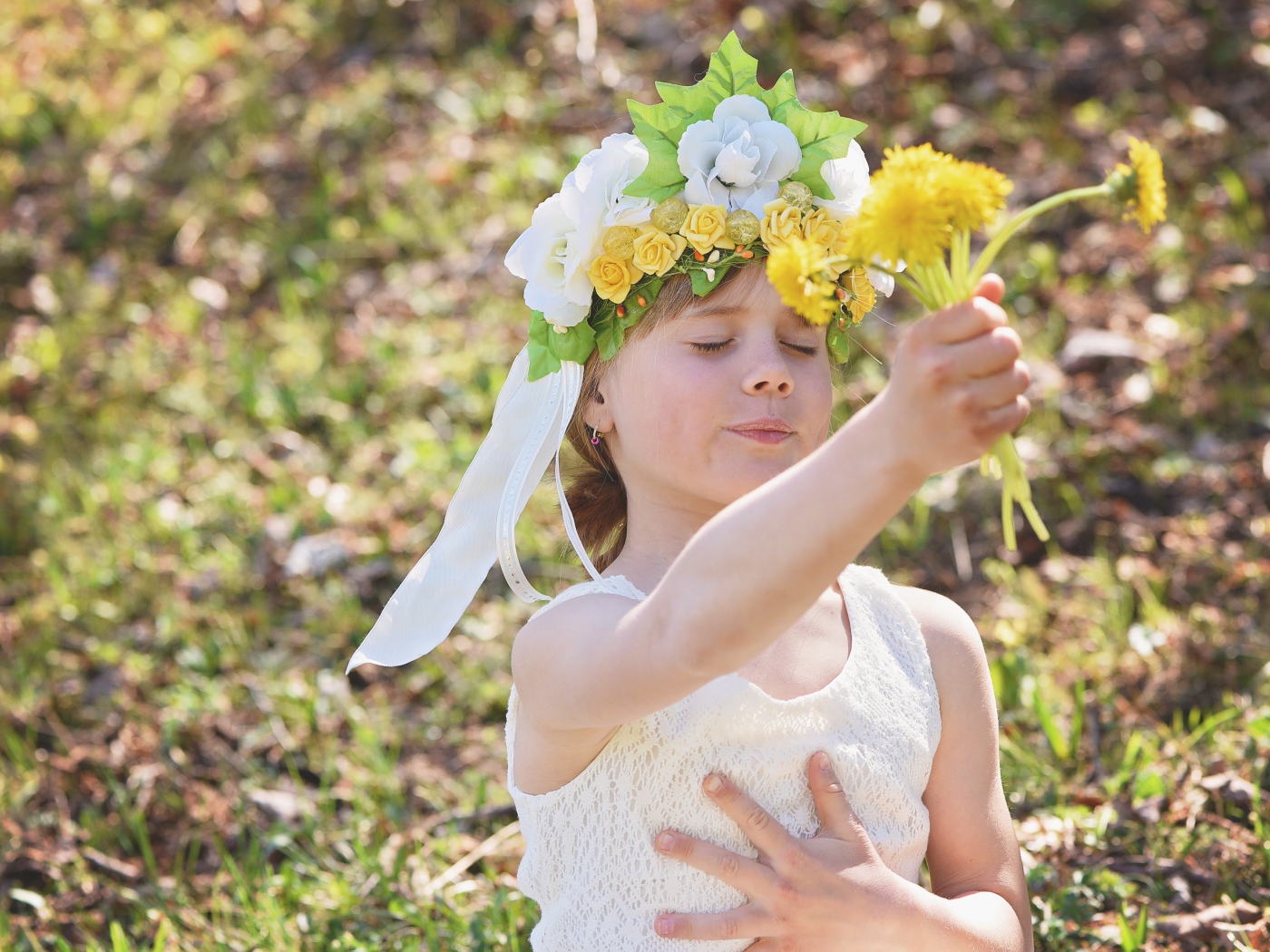Маленькая девочка с букетом одуванчиках в руке 