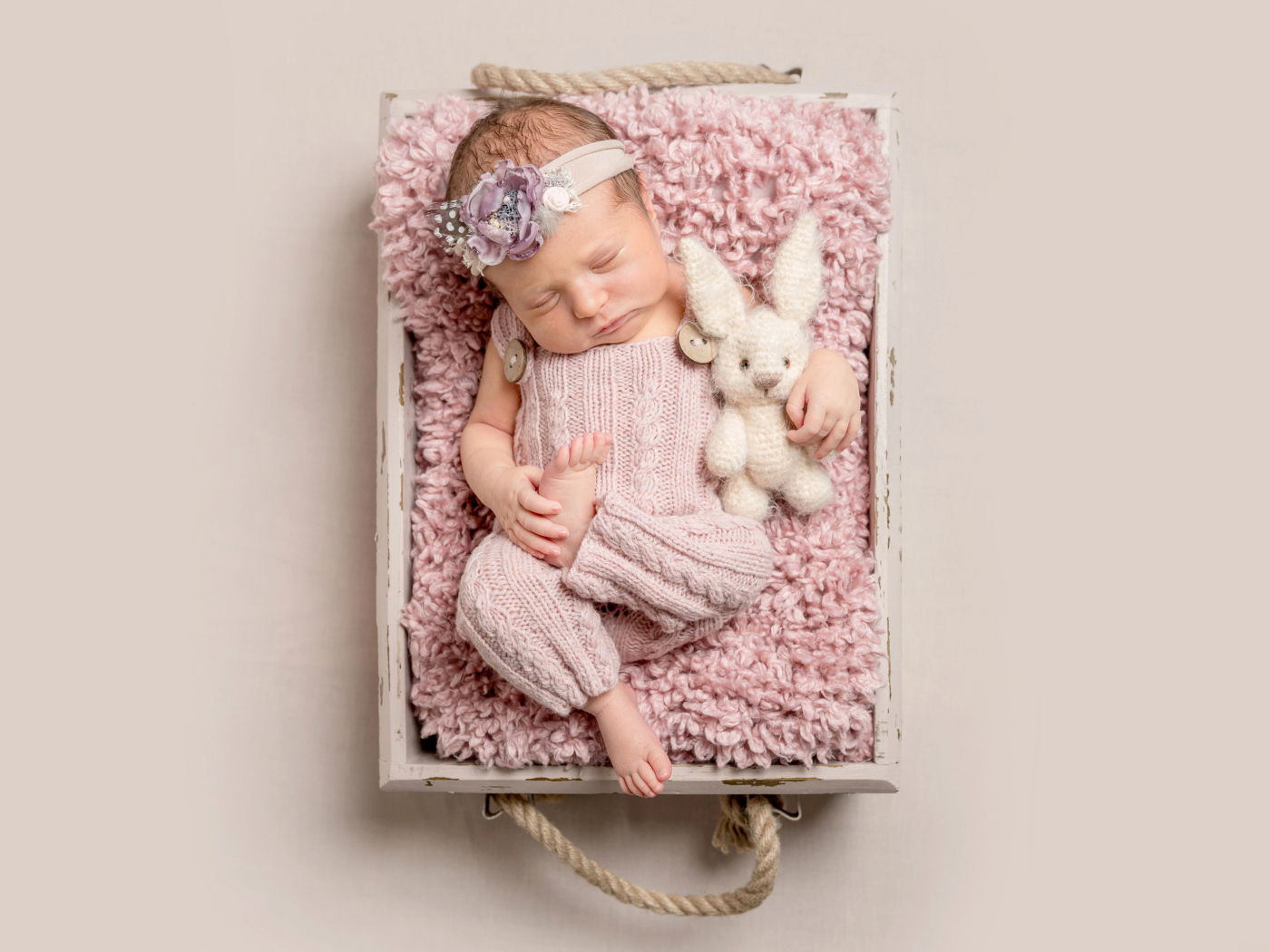 Маленькая новорожденная девочка спит в ящике 