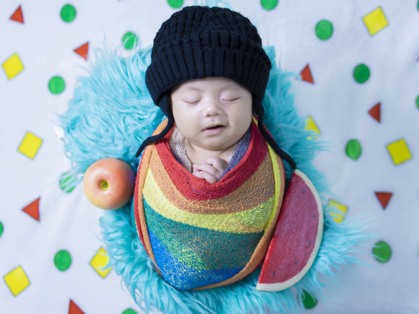 Маленький спящий ребенок в черной шапке 