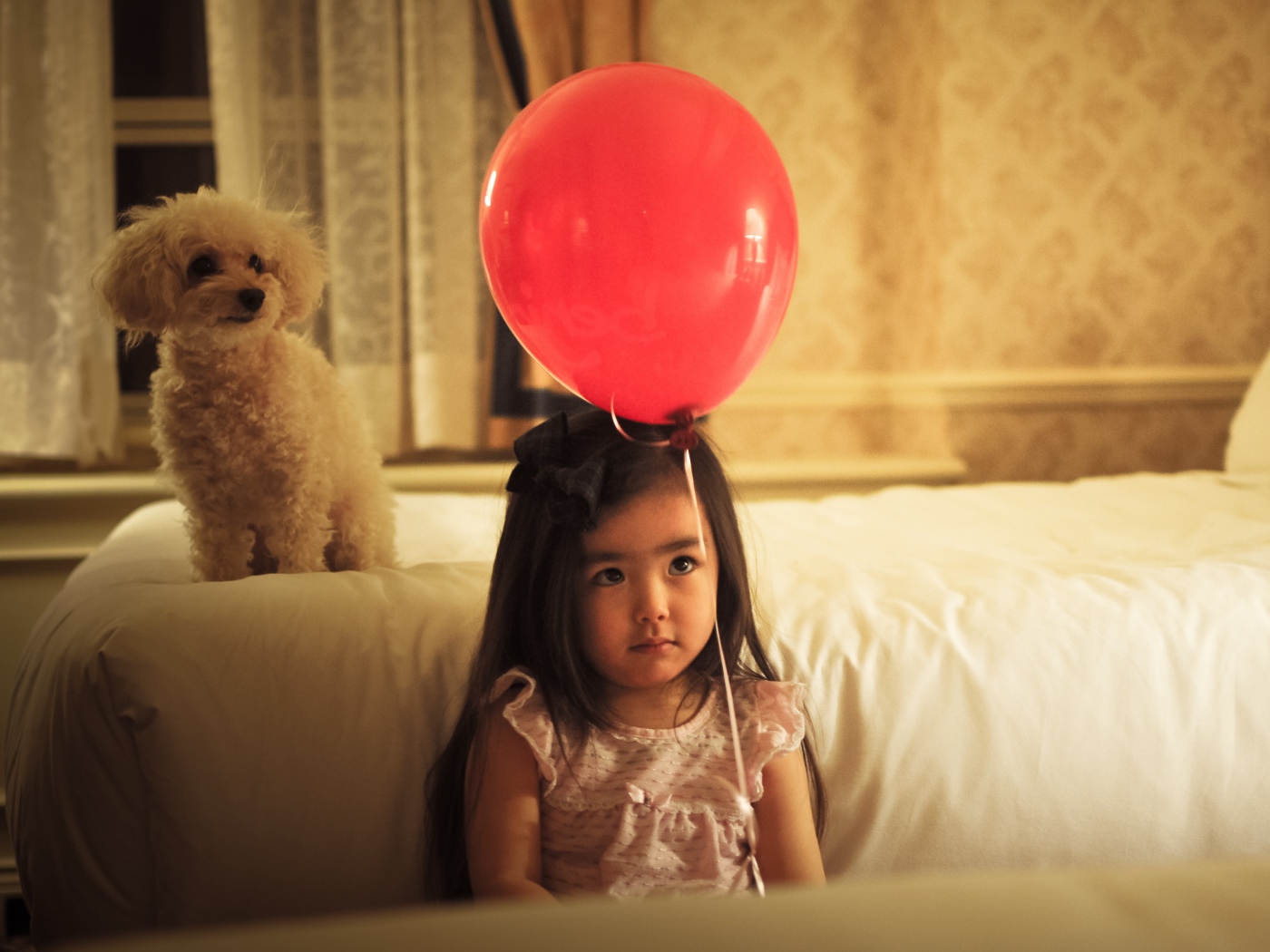 Грустная девочка азиатка с красным шариком