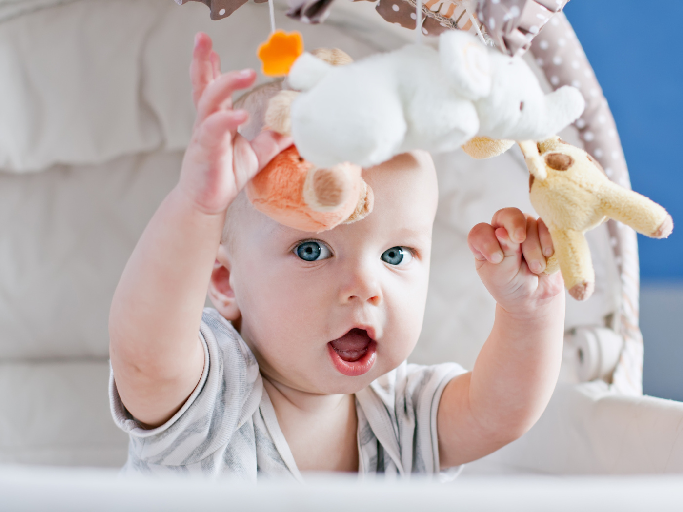 Маленький грудной ребенок в коляске с игрушками 