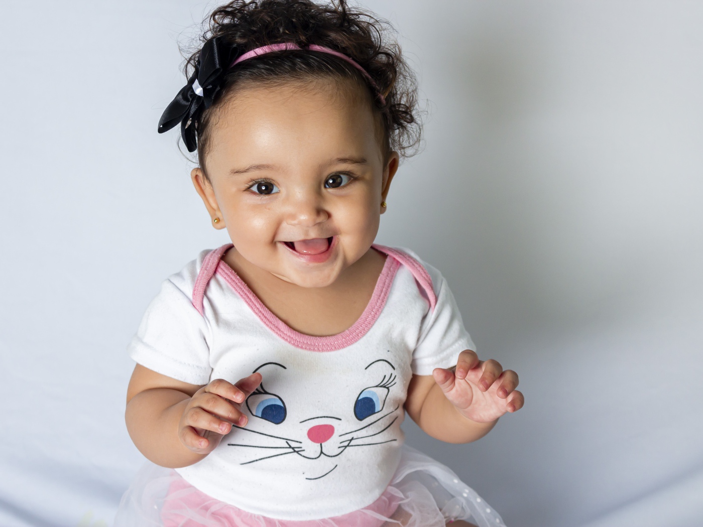 Улыбающаяся маленькая девочка на сером фоне 