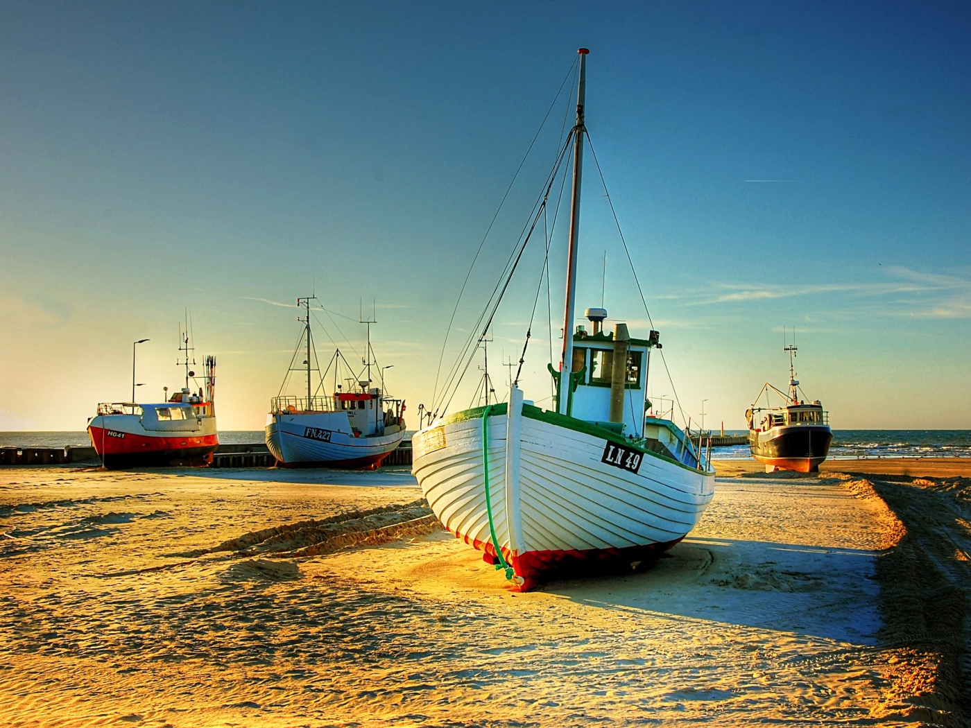 Рыболовные лодки в лучах солнца на берегу 