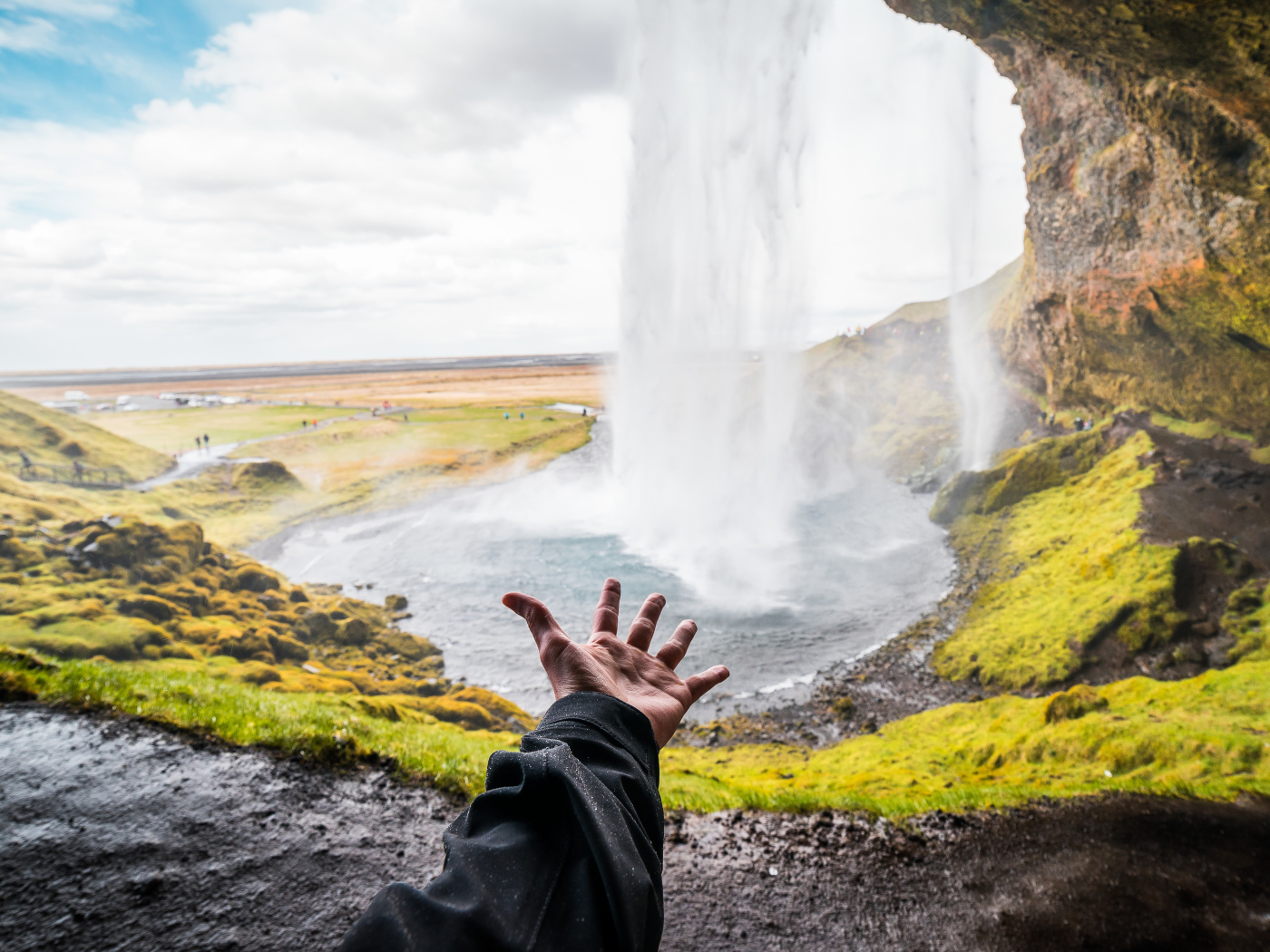Рука тянется к водопаду Сельяландсфосс, Исландия