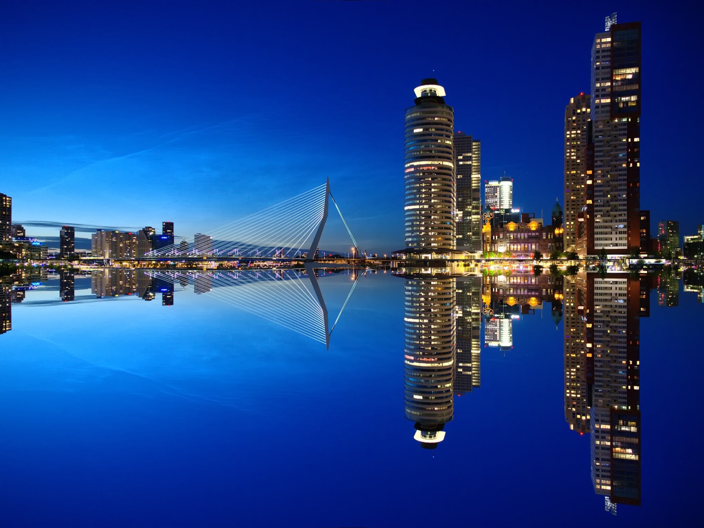Небоскребы и мост отражаются в тихой воде