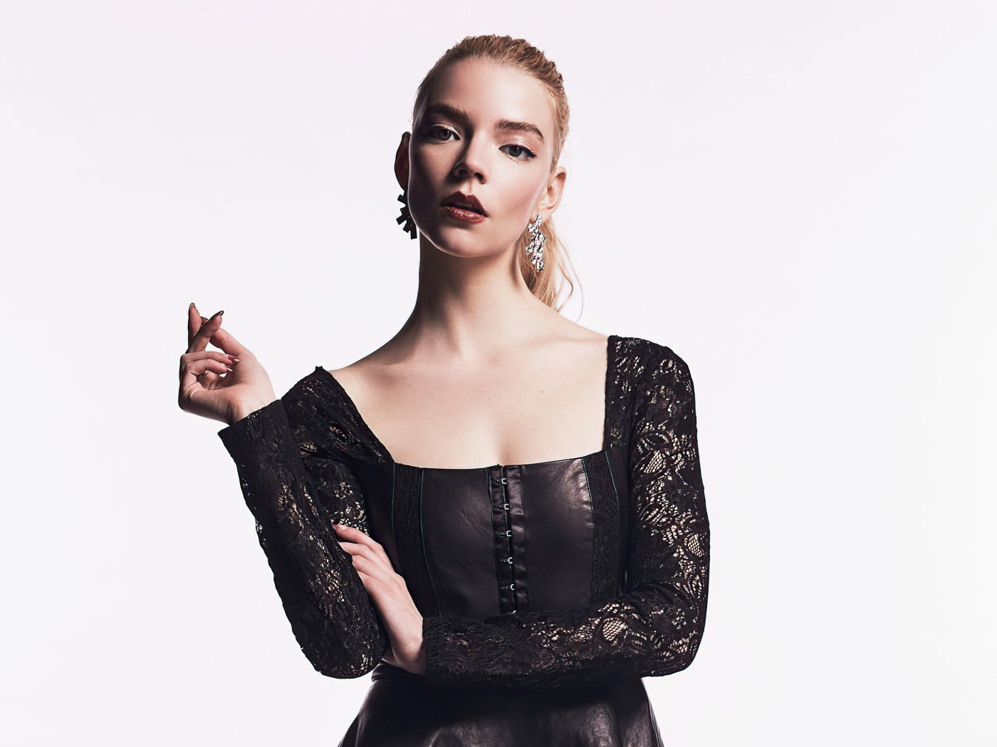 Актриса Аня Тейлор-Джой в черном наряде на белом фоне