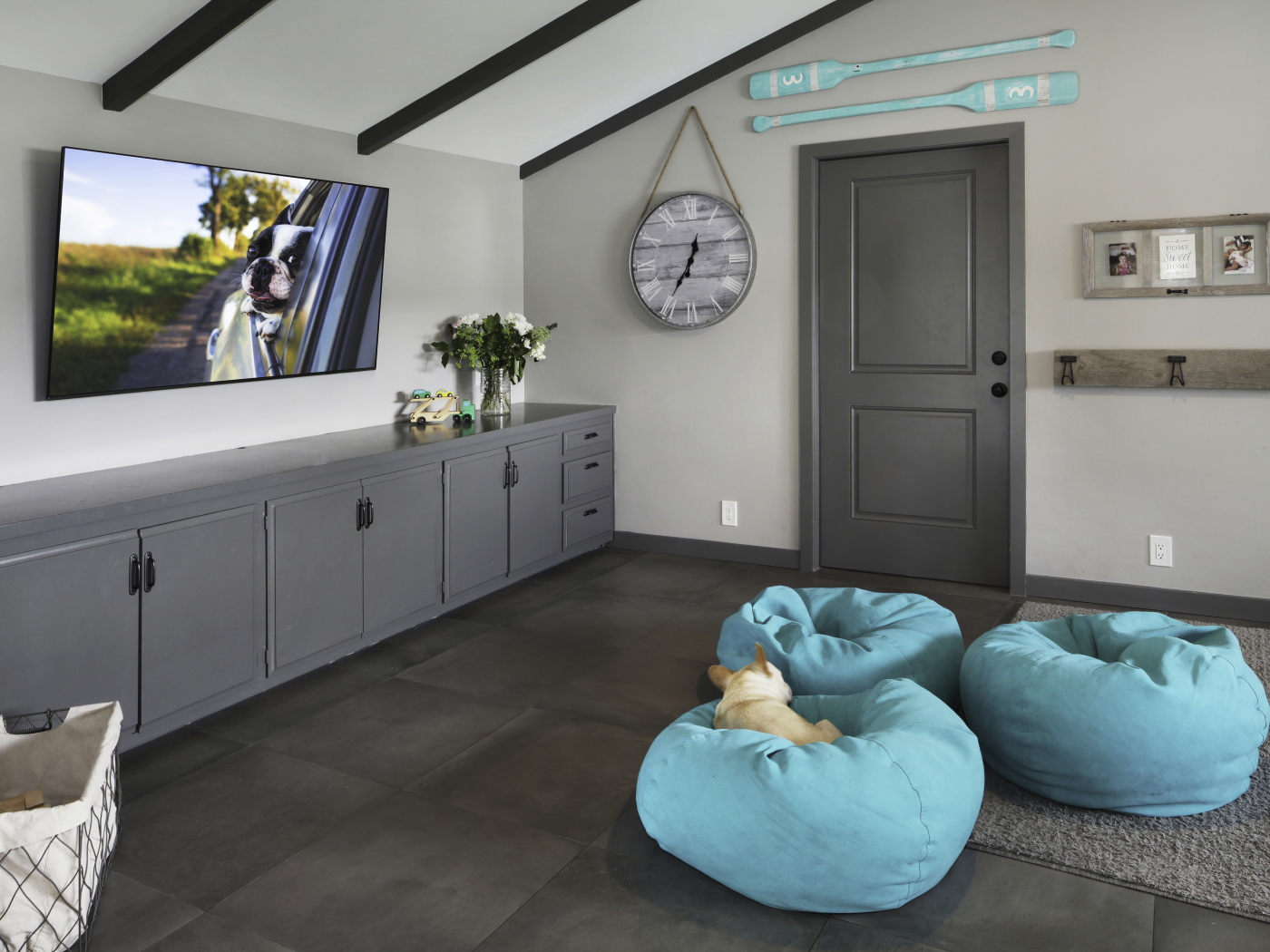 Голубые кресла в комнате с большим телевизором 