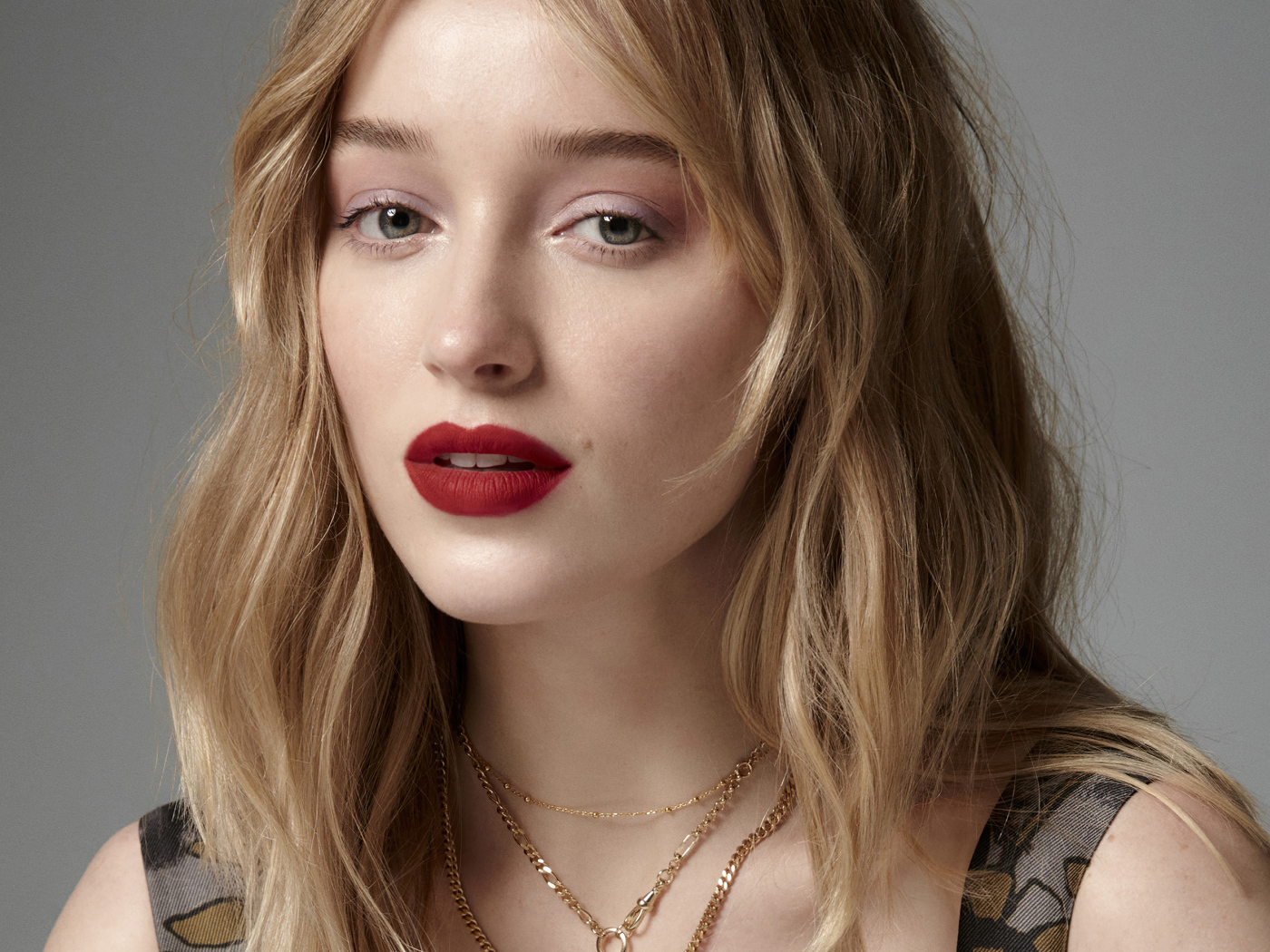 Яркая помада на губах актрисы Фиби Дайневор на сером фоне