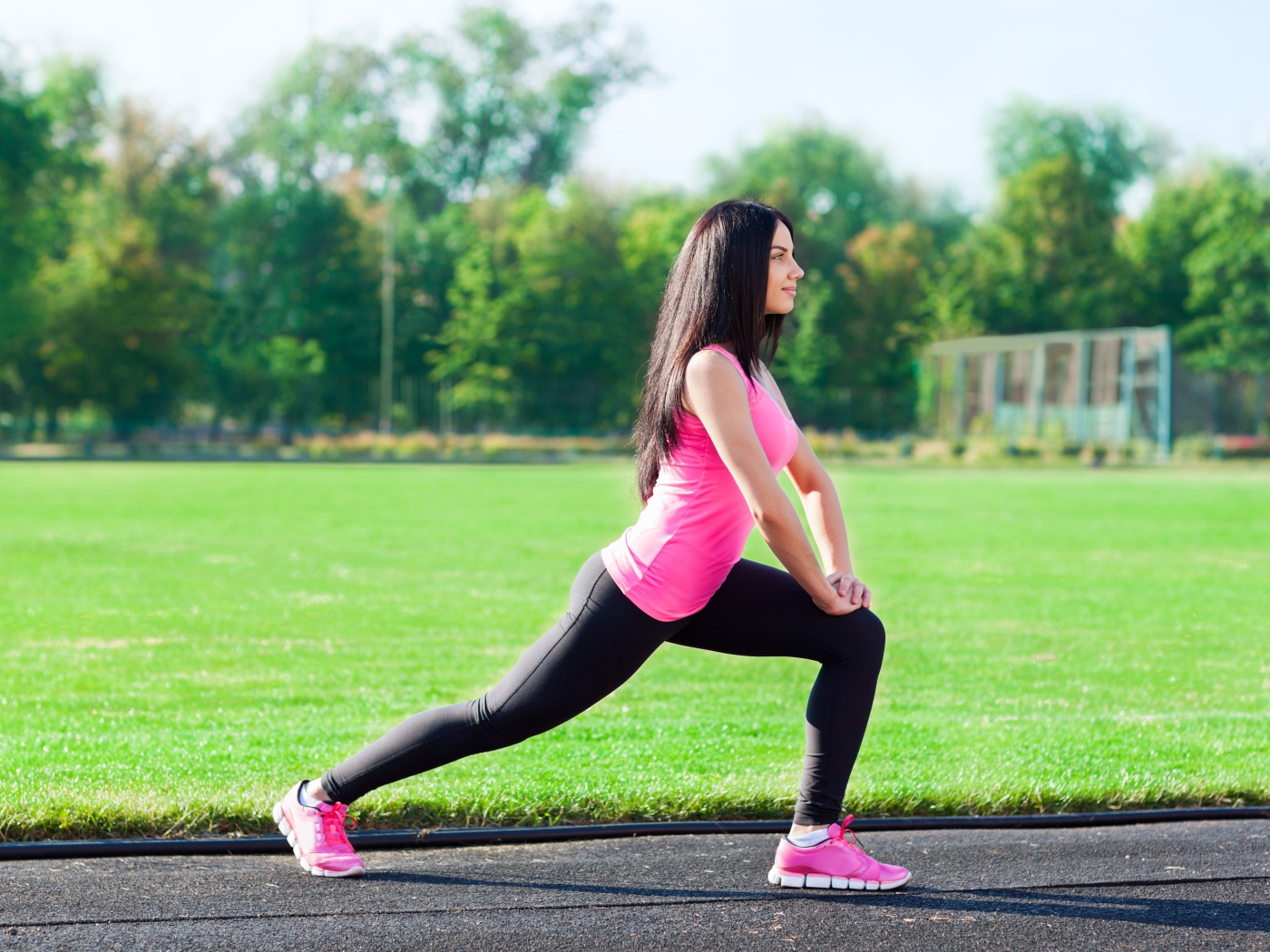 Девушка делает растяжку на поле 