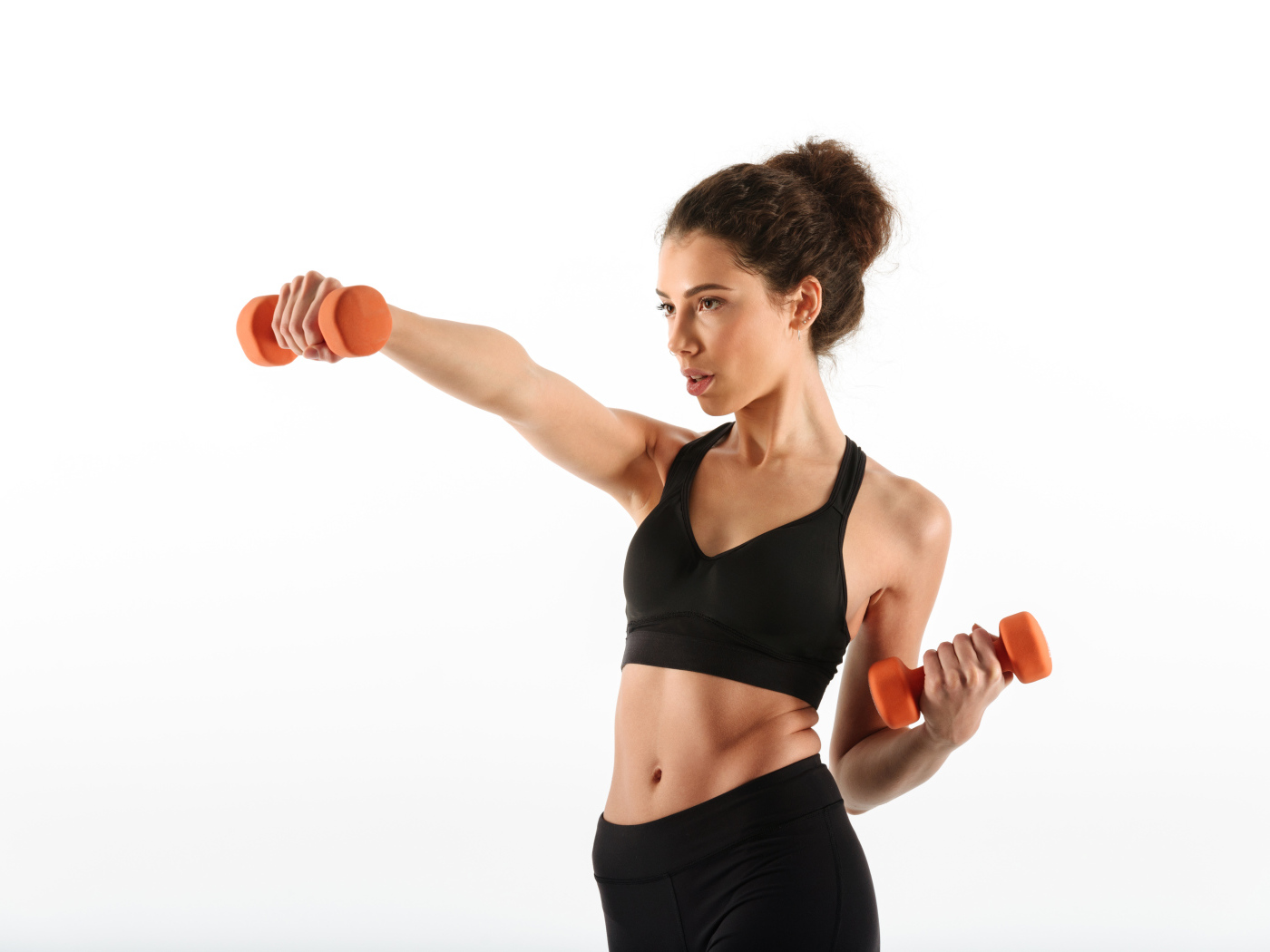 Девушка качает руки гантелями на белом фоне