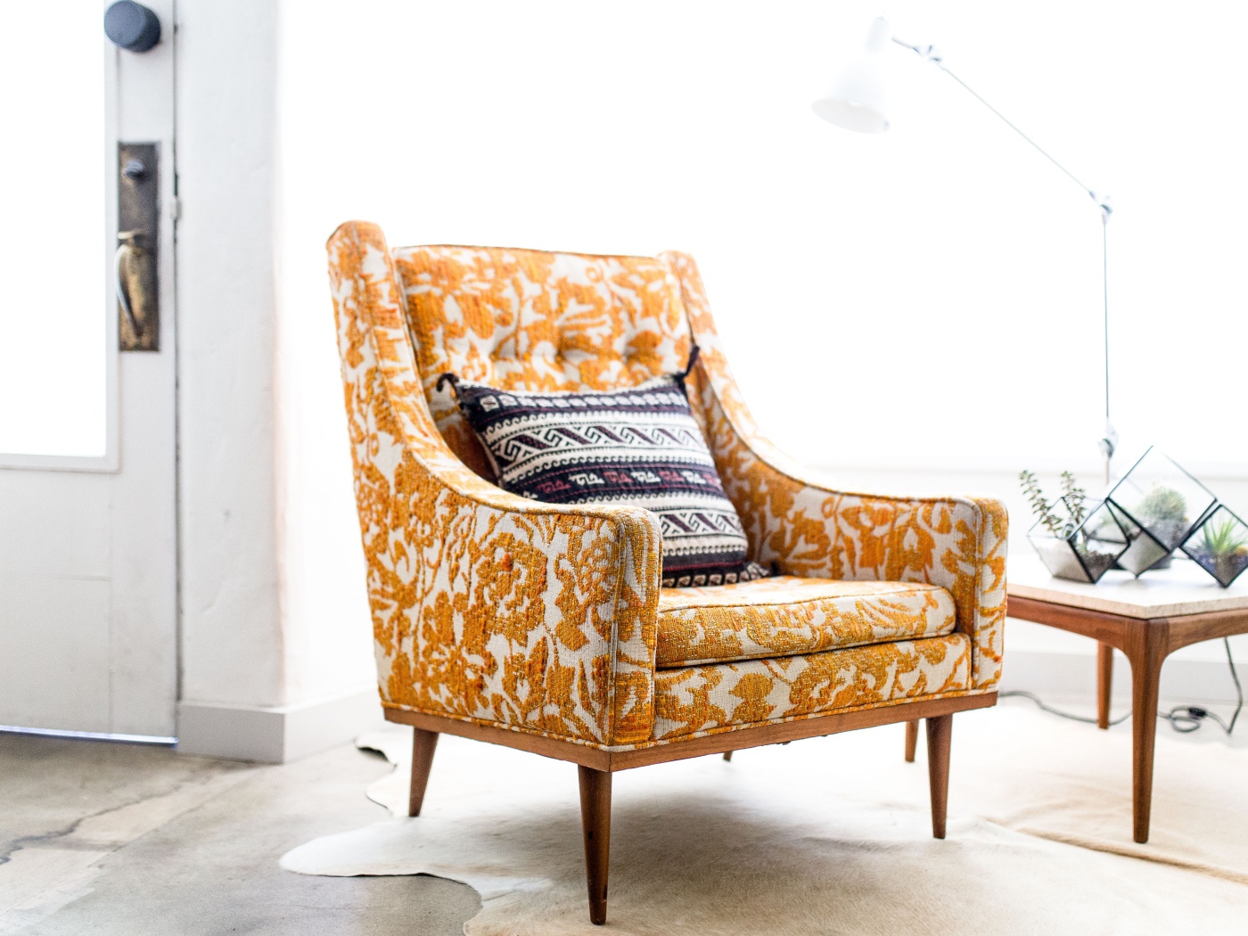 Старое кресло с подушкой в комнате 