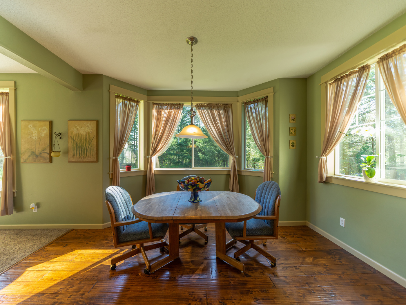 Деревянный стол стоит в гостиной с зелеными стенами