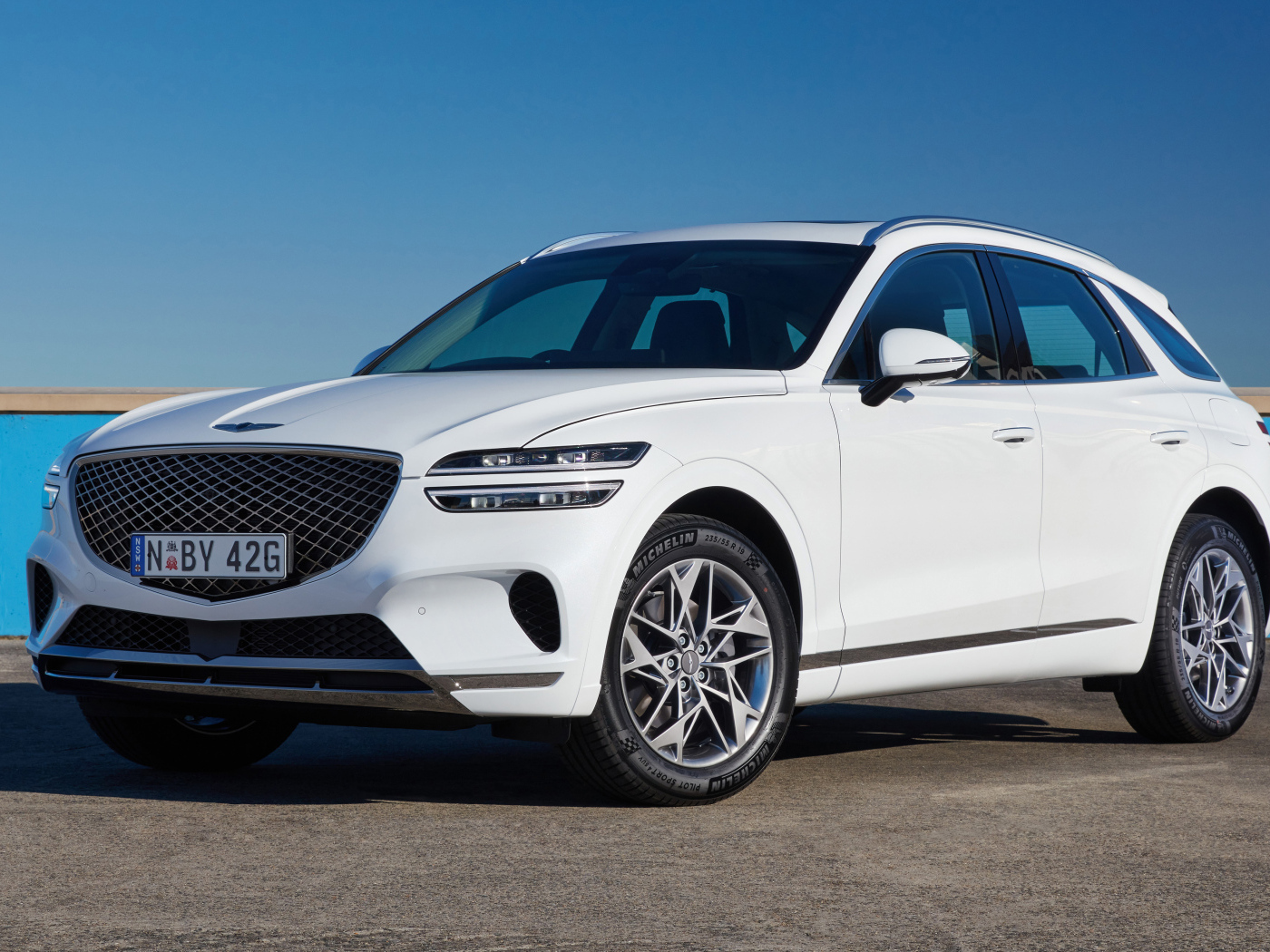 Белый Genesis GV70 2.5T на фоне неба 