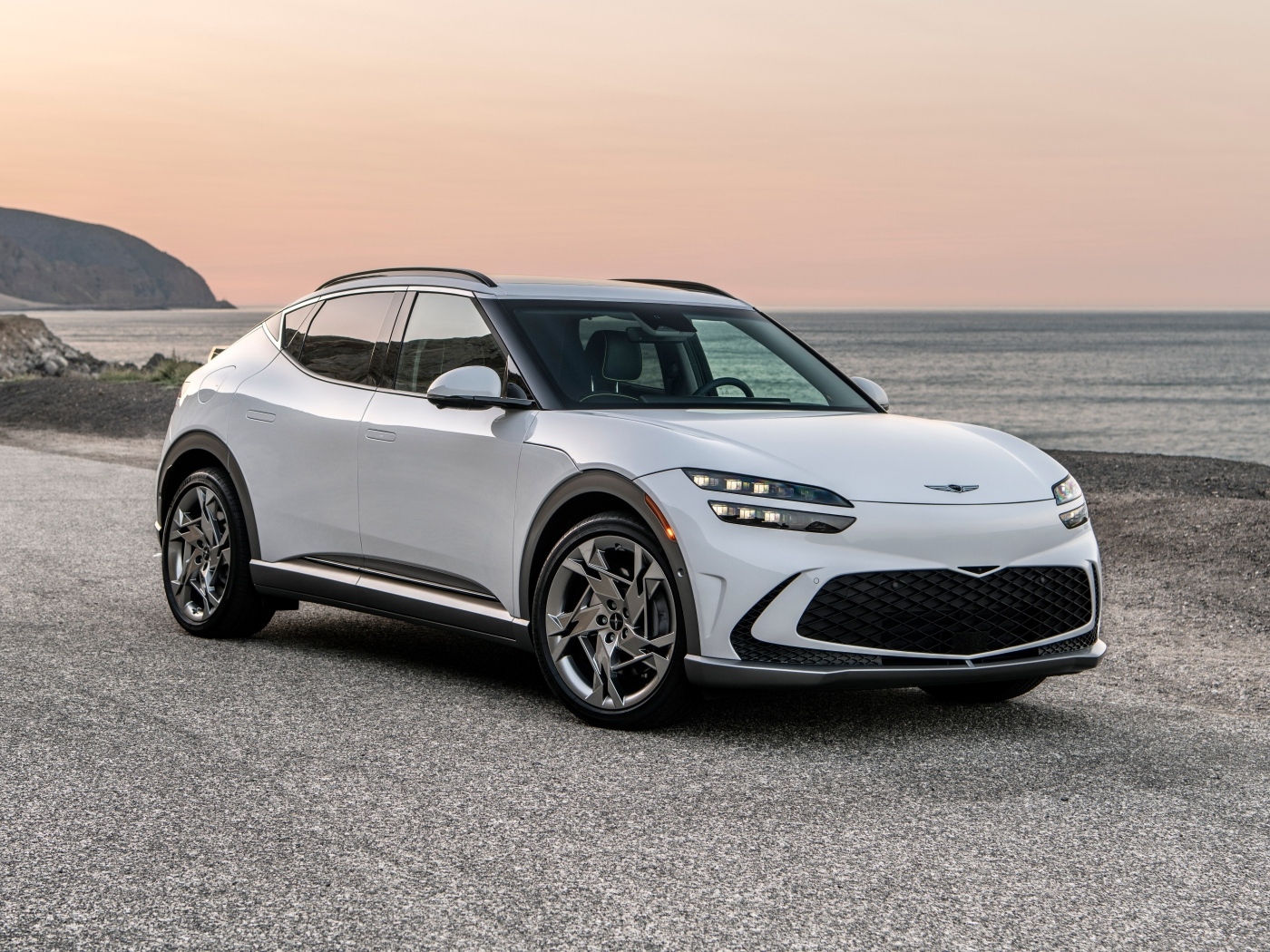 Белый автомобиль Genesis GV60, 2023 года на пляже