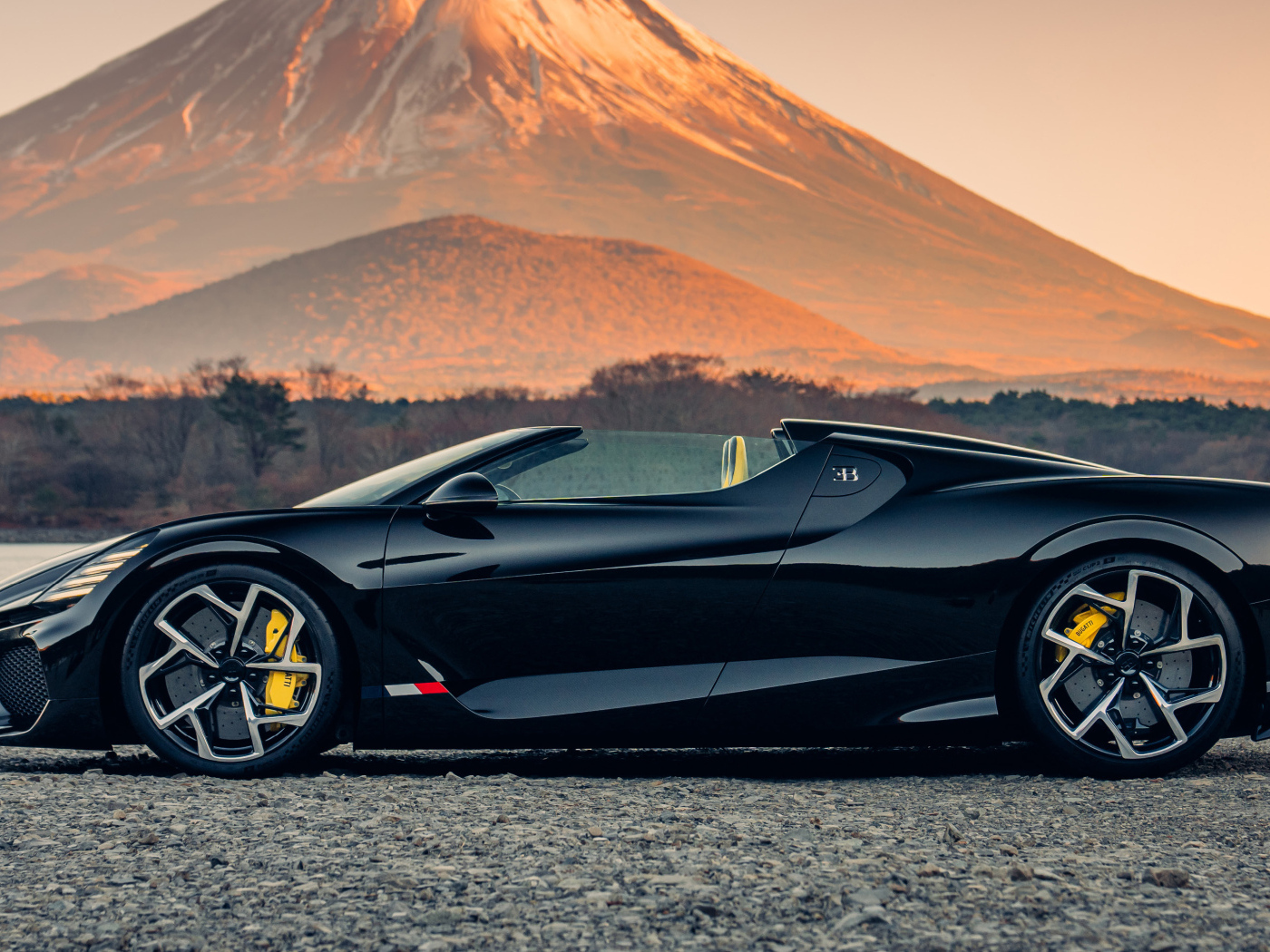 Черный автомобиль Bugatti W16 Mistral  на фоне горы