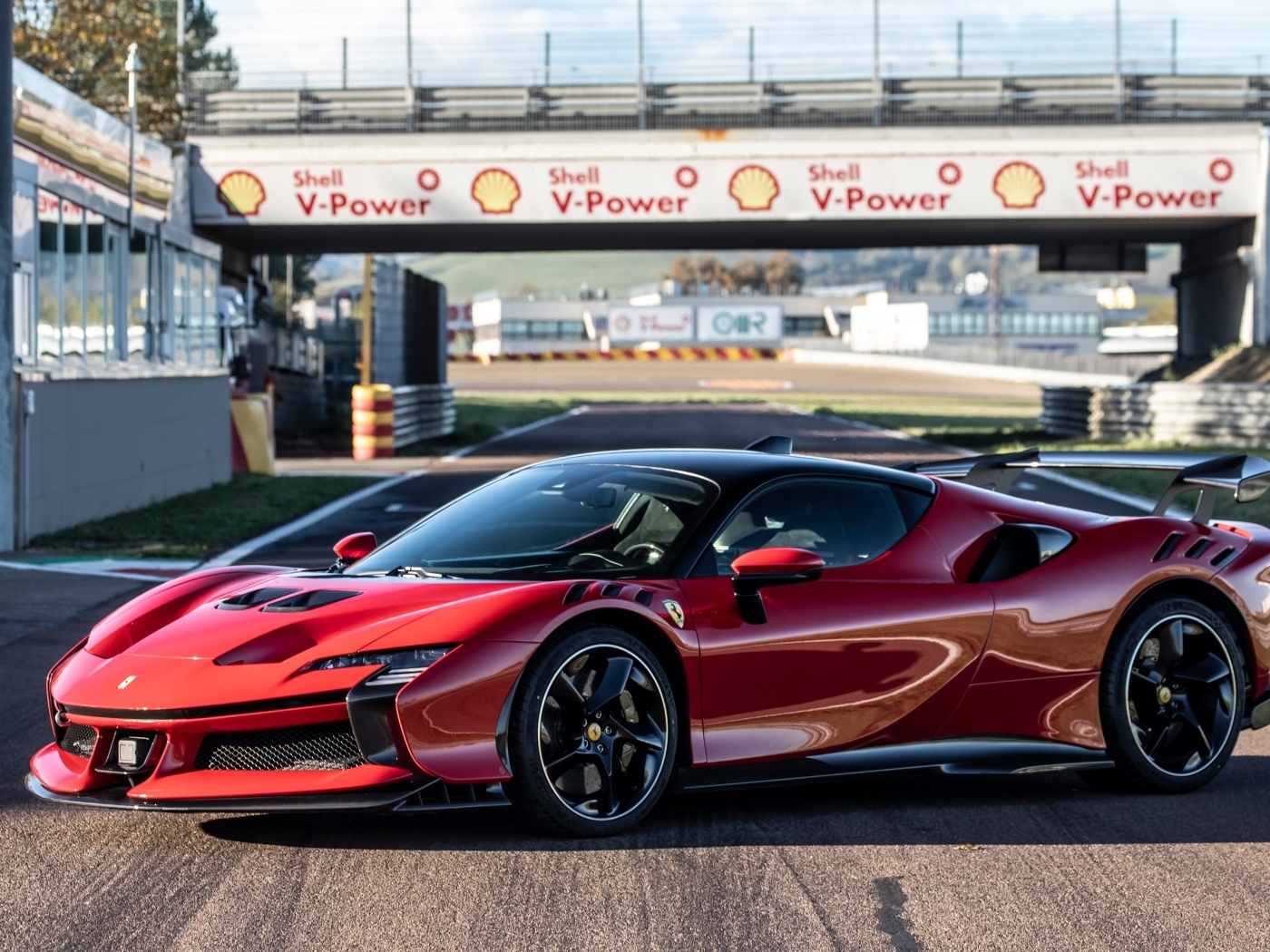 Красный автомобиль Ferrari SF90 XX Stradale на стадионе