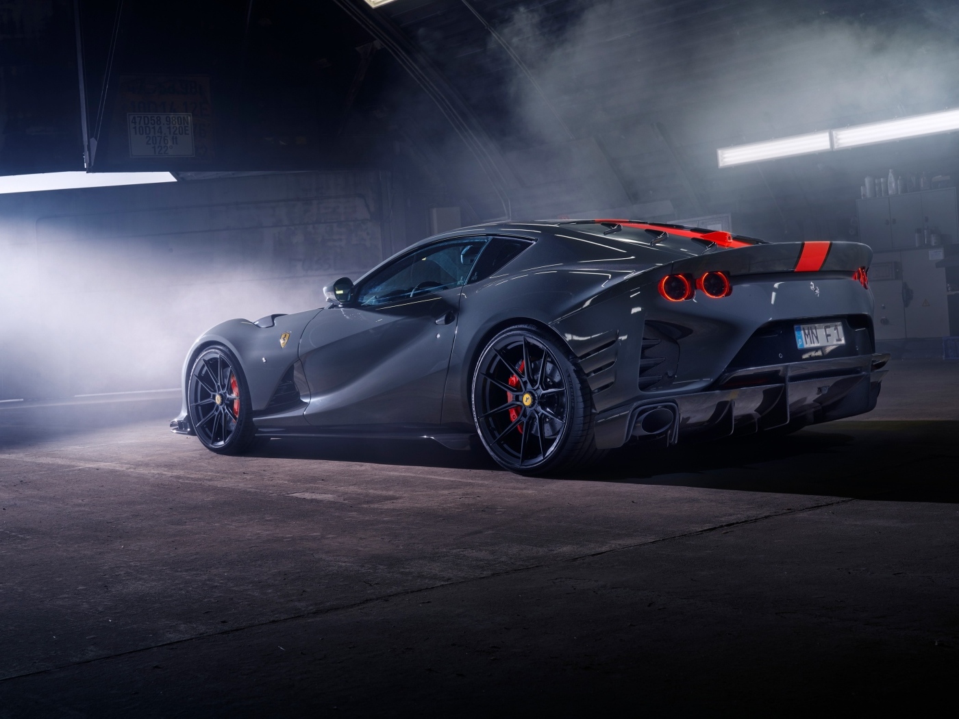 Серебристый спортивный автомобиль Ferrari 812 вид сзади