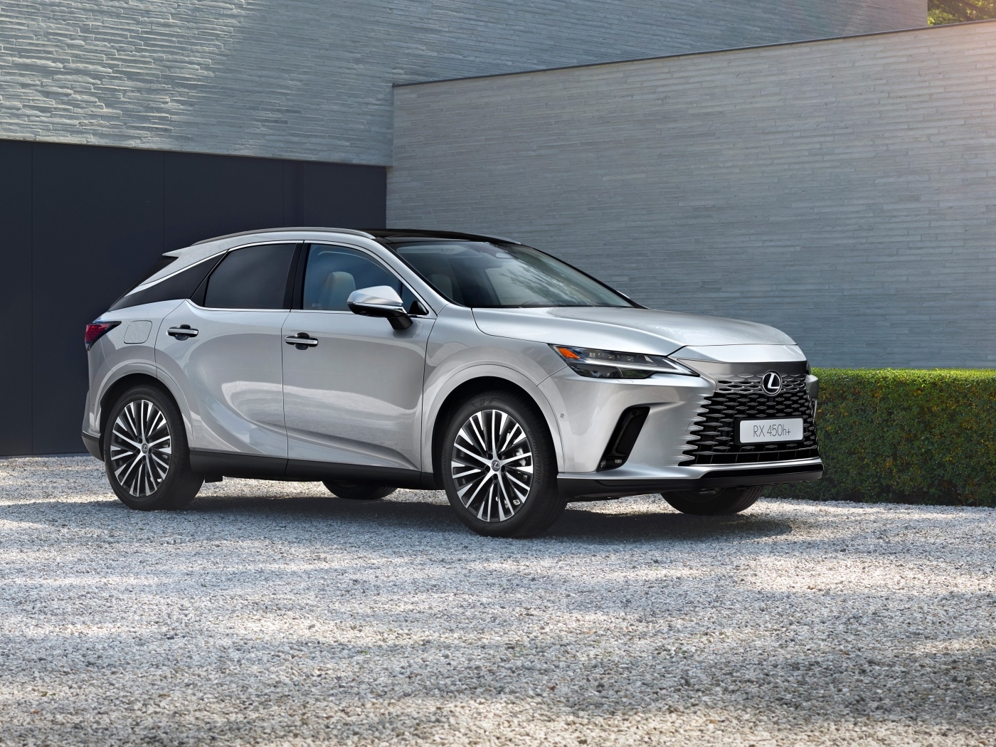 Серебристый внедорожник Lexus RX 450h+ у здания