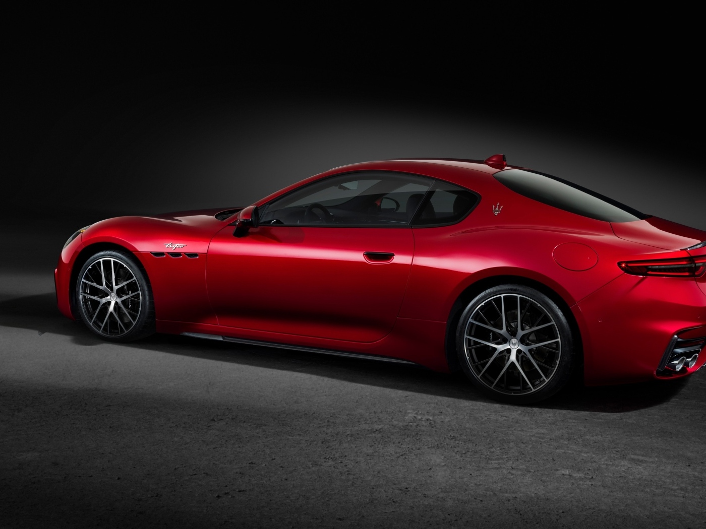 Красный автомобиль Maserati GranTurismo Trofeo 2023 на сером фоне