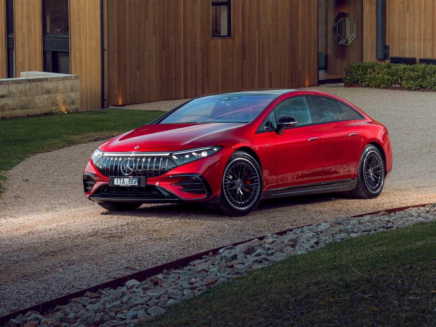 Красный автомобиль Mercedes-AMG EQS 53 4MATIC+  у дома