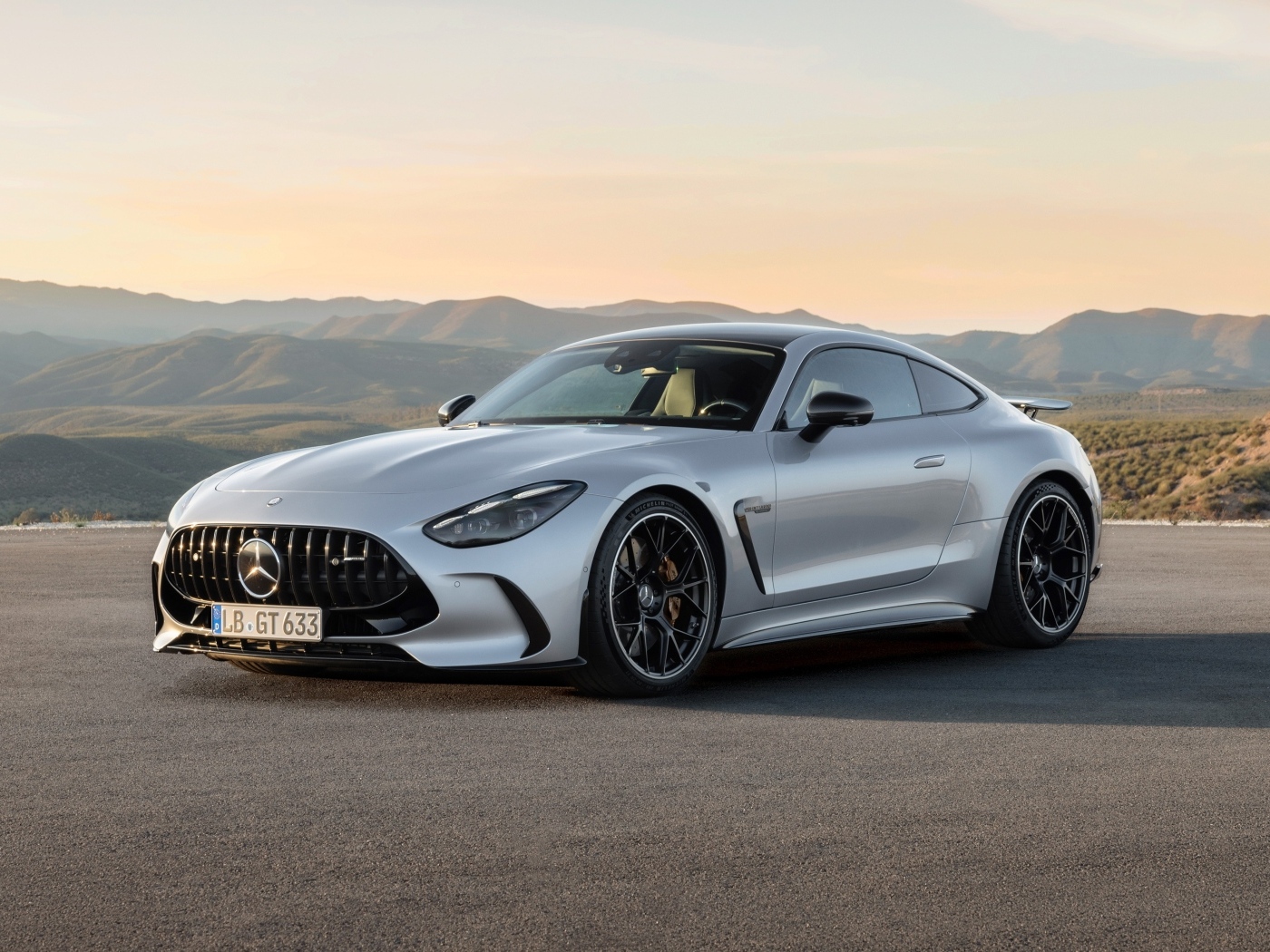 Серебристый автомобиль Mercedes-AMG GT 63 4MATIC+ 2023 года на фоне гор