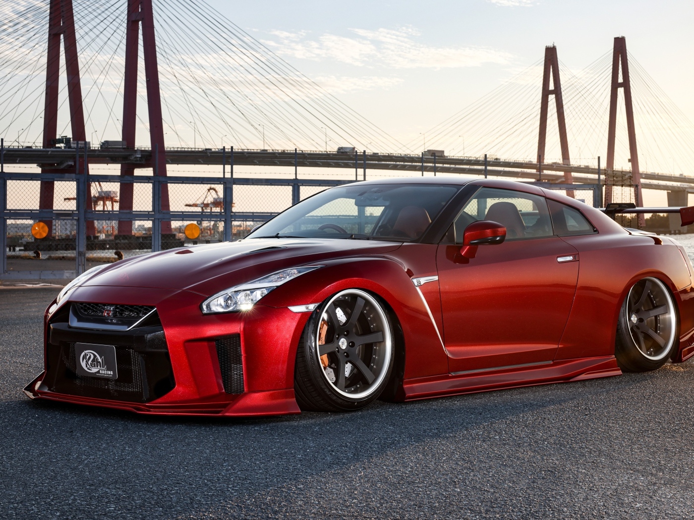 Красный автомобиль Nissan GTR 35R на фоне моста