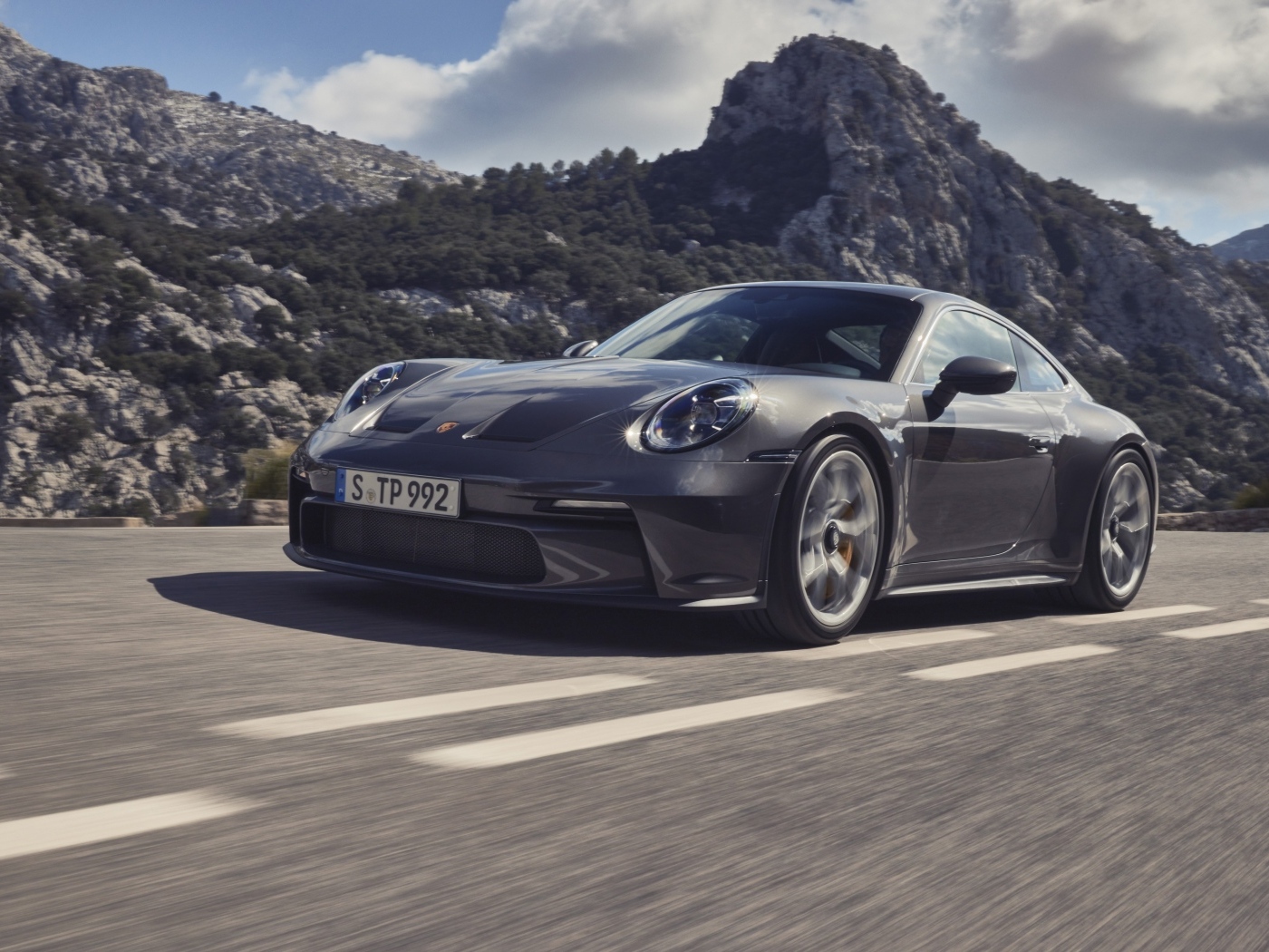 Автомобиль Porsche 911 GT3 Touring 2023 года на фоне гор