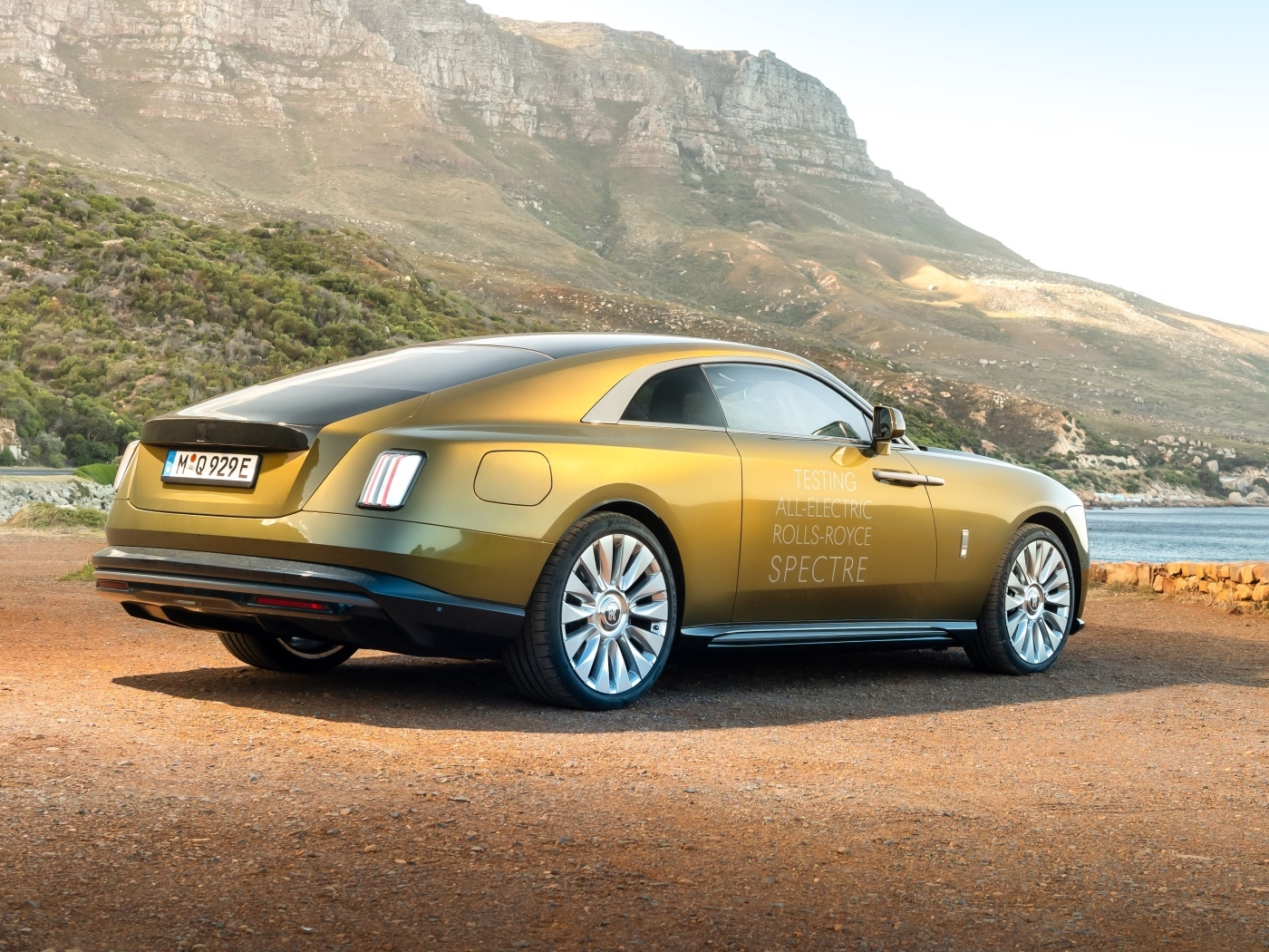 Золотистый Rolls-Royce Spectre вид сзади